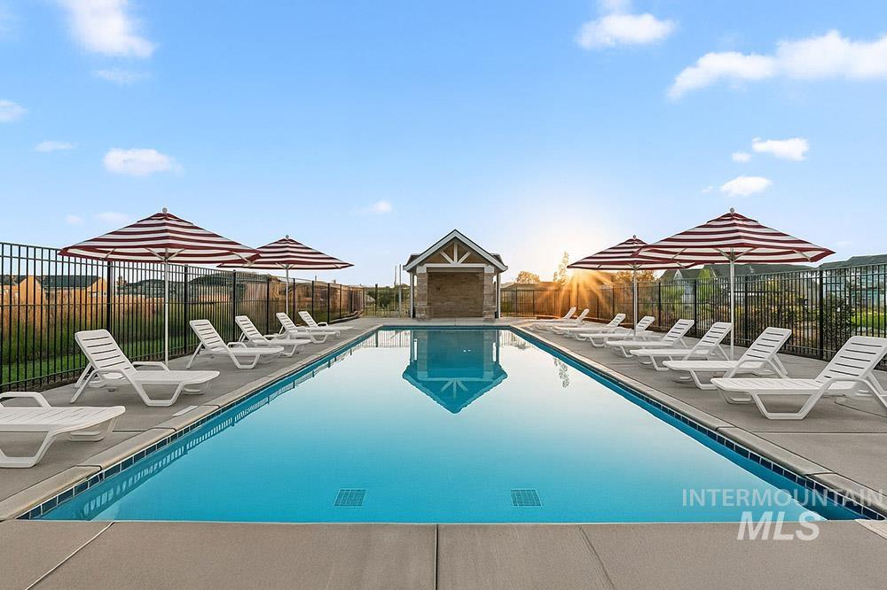 Community pool with a patio area and a fenced backyard