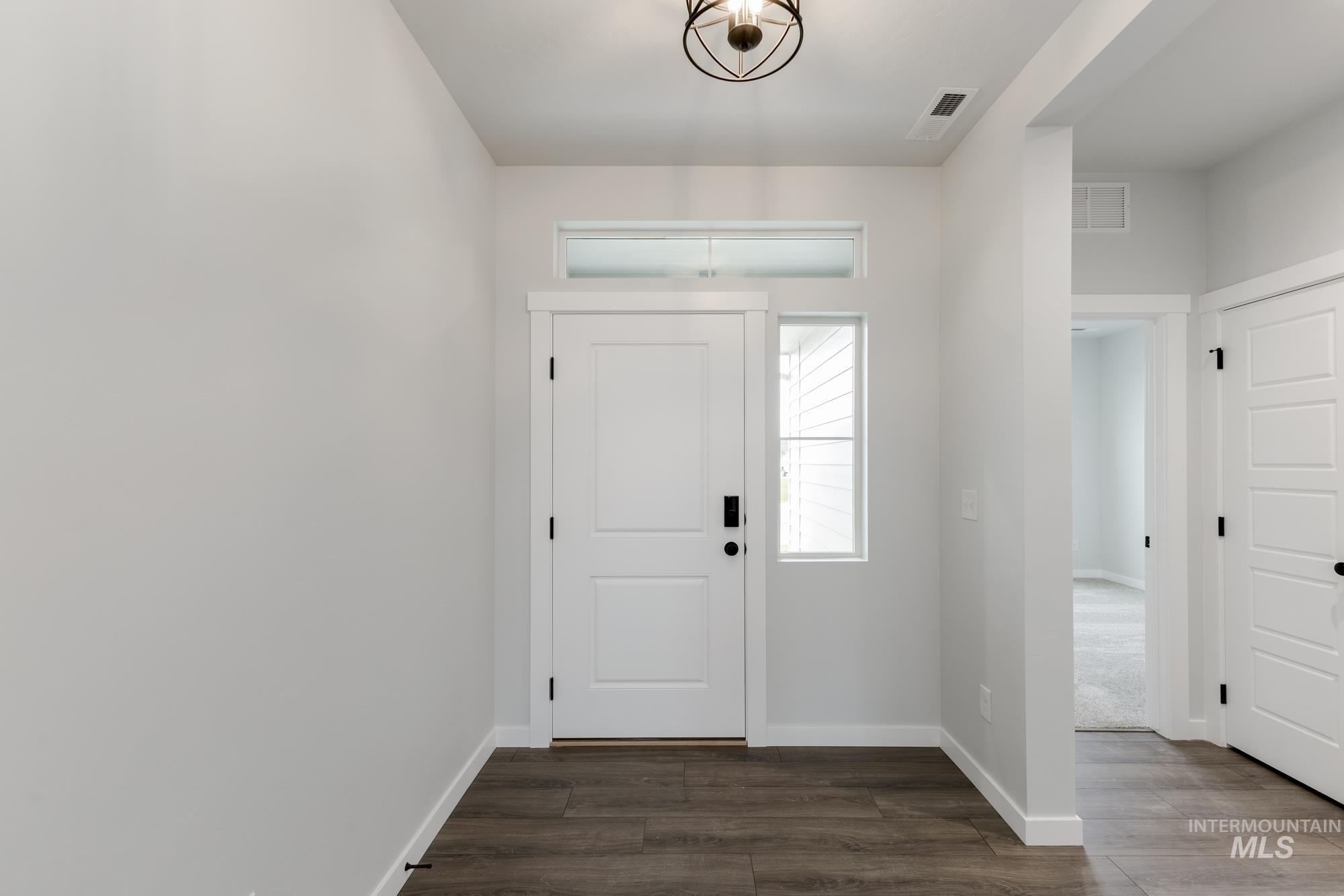 Foyer featuring dark wood finished floors and baseboards