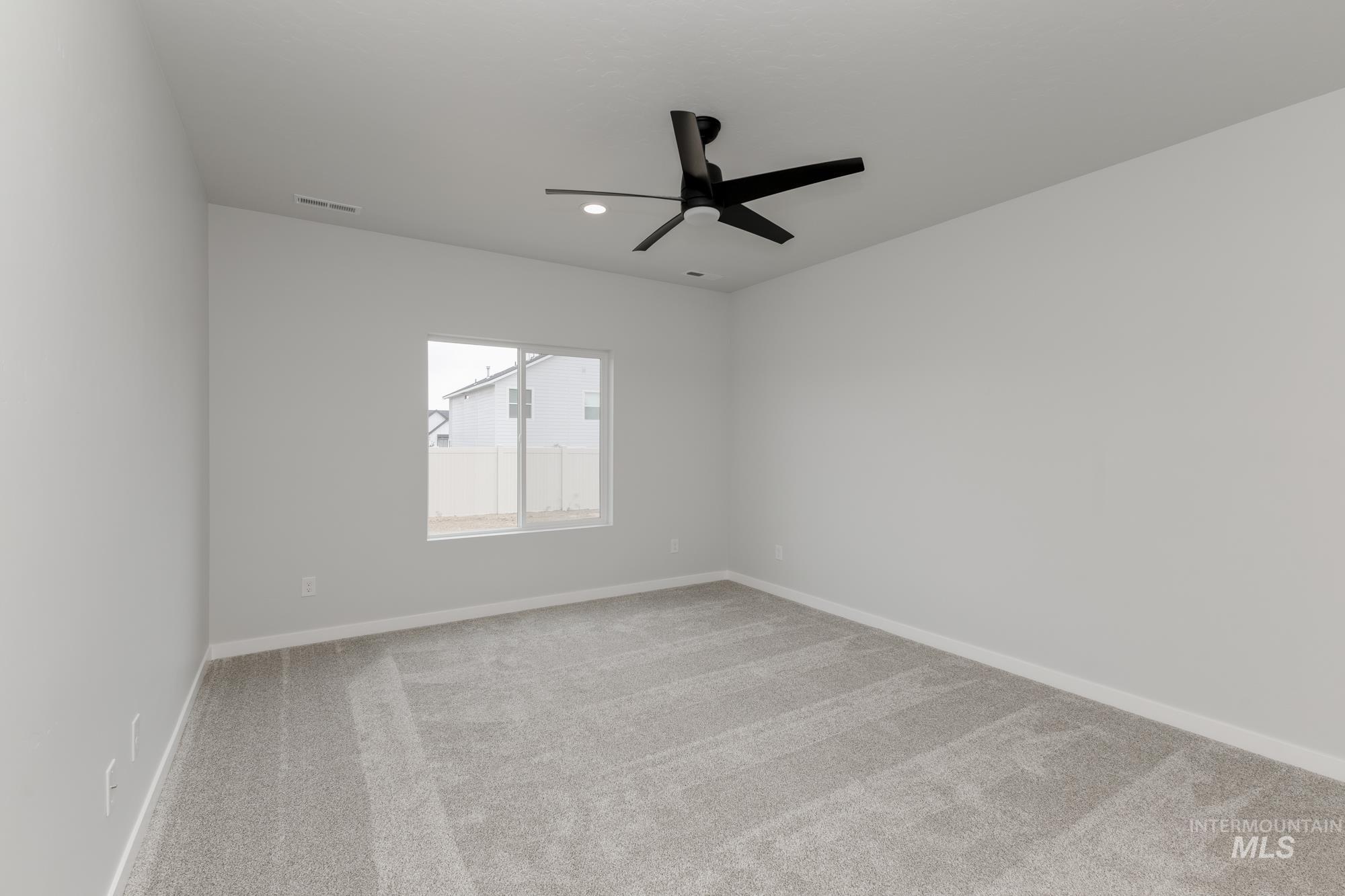 Carpeted empty room with ceiling fan and recessed lighting