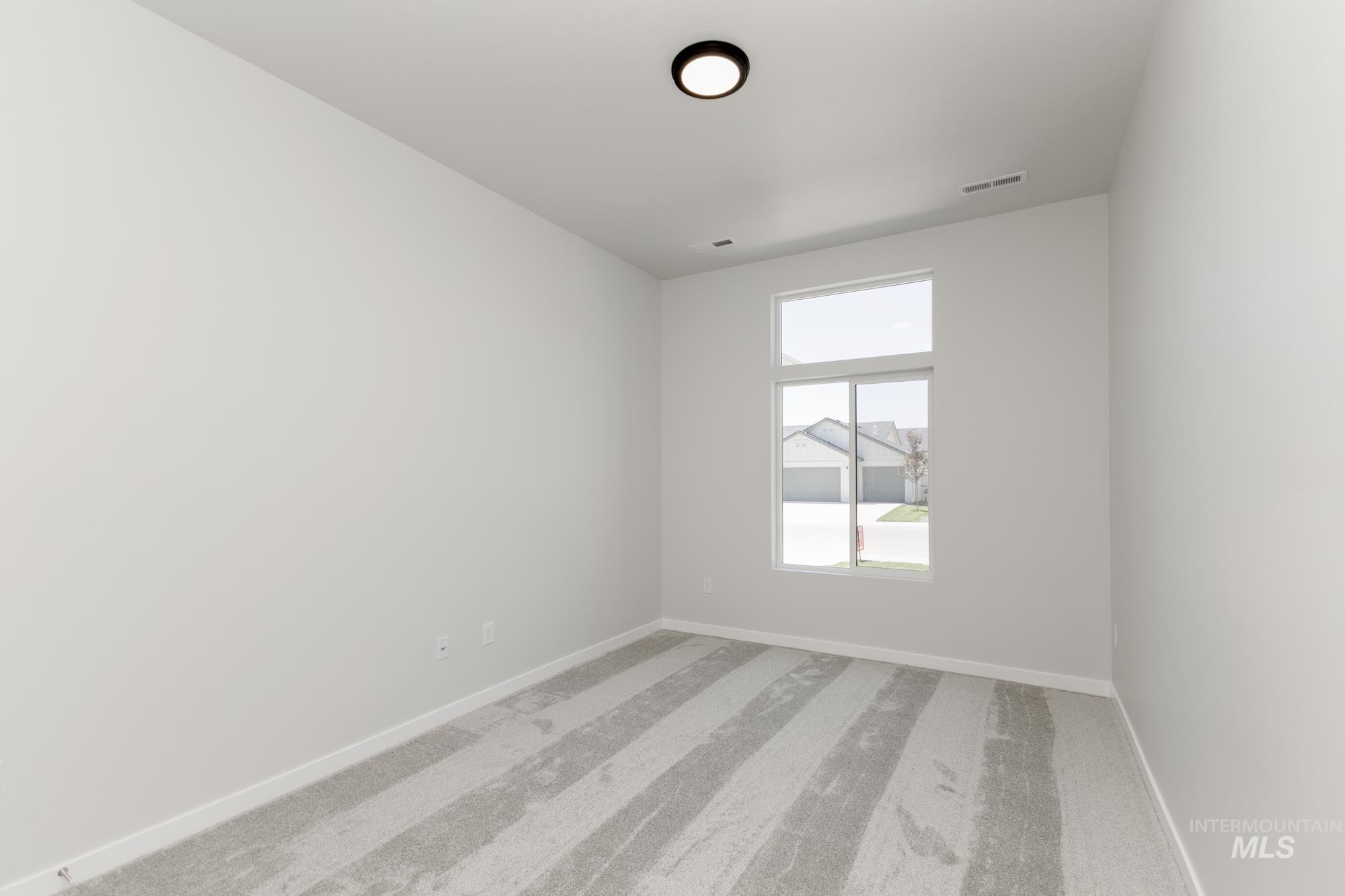Empty room with light colored carpet