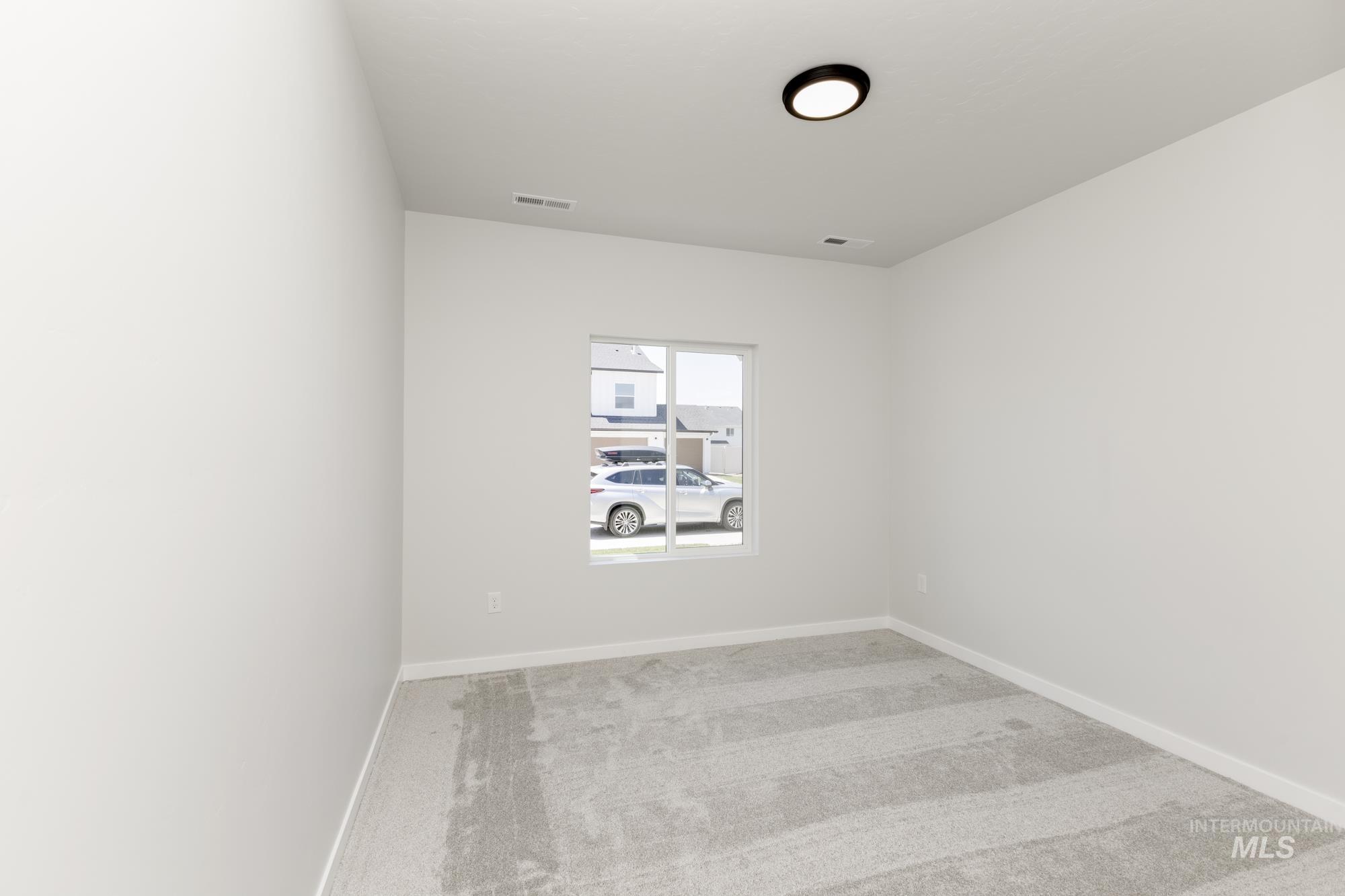 Carpeted empty room with baseboards