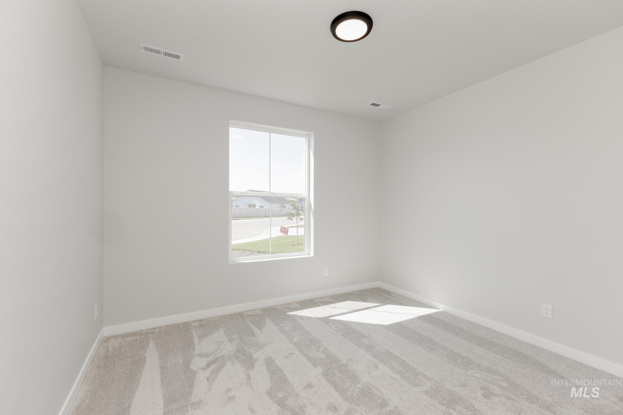 Unfurnished room featuring light colored carpet and baseboards