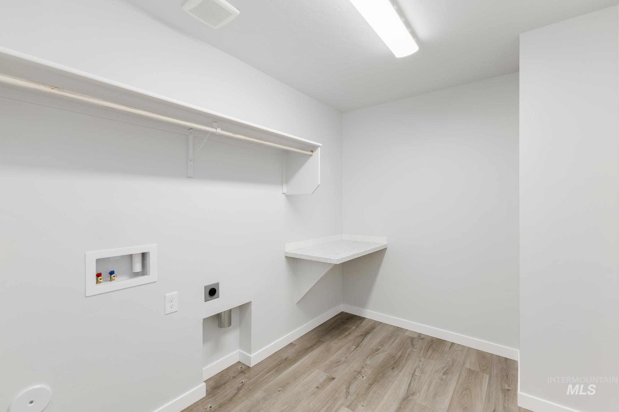 Washroom featuring light wood-style flooring, washer hookup, and hookup for an electric dryer