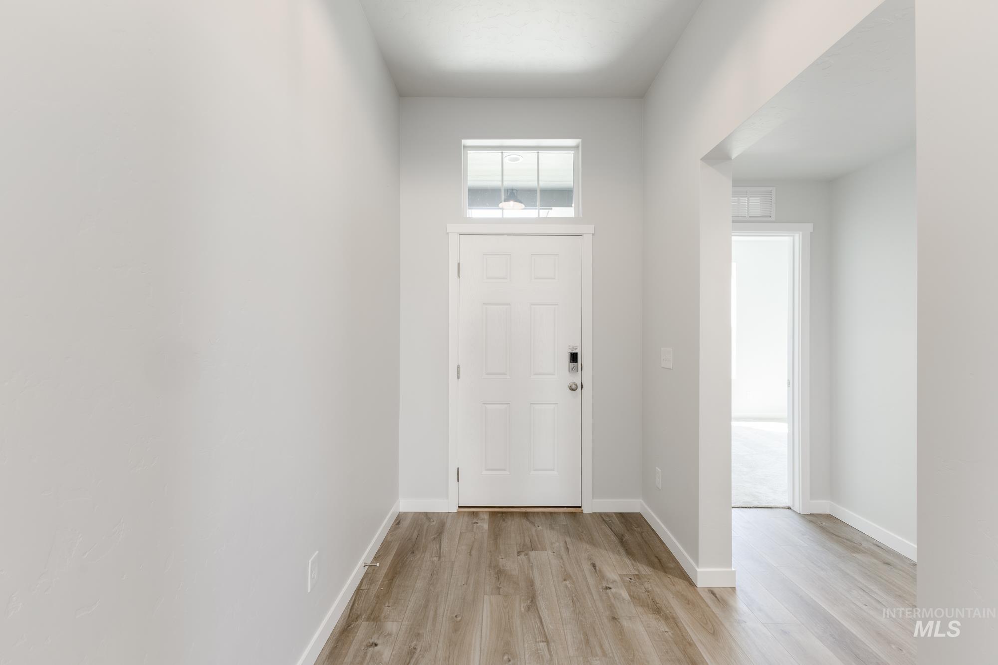 Foyer entrance with light wood finished floors and baseboards
