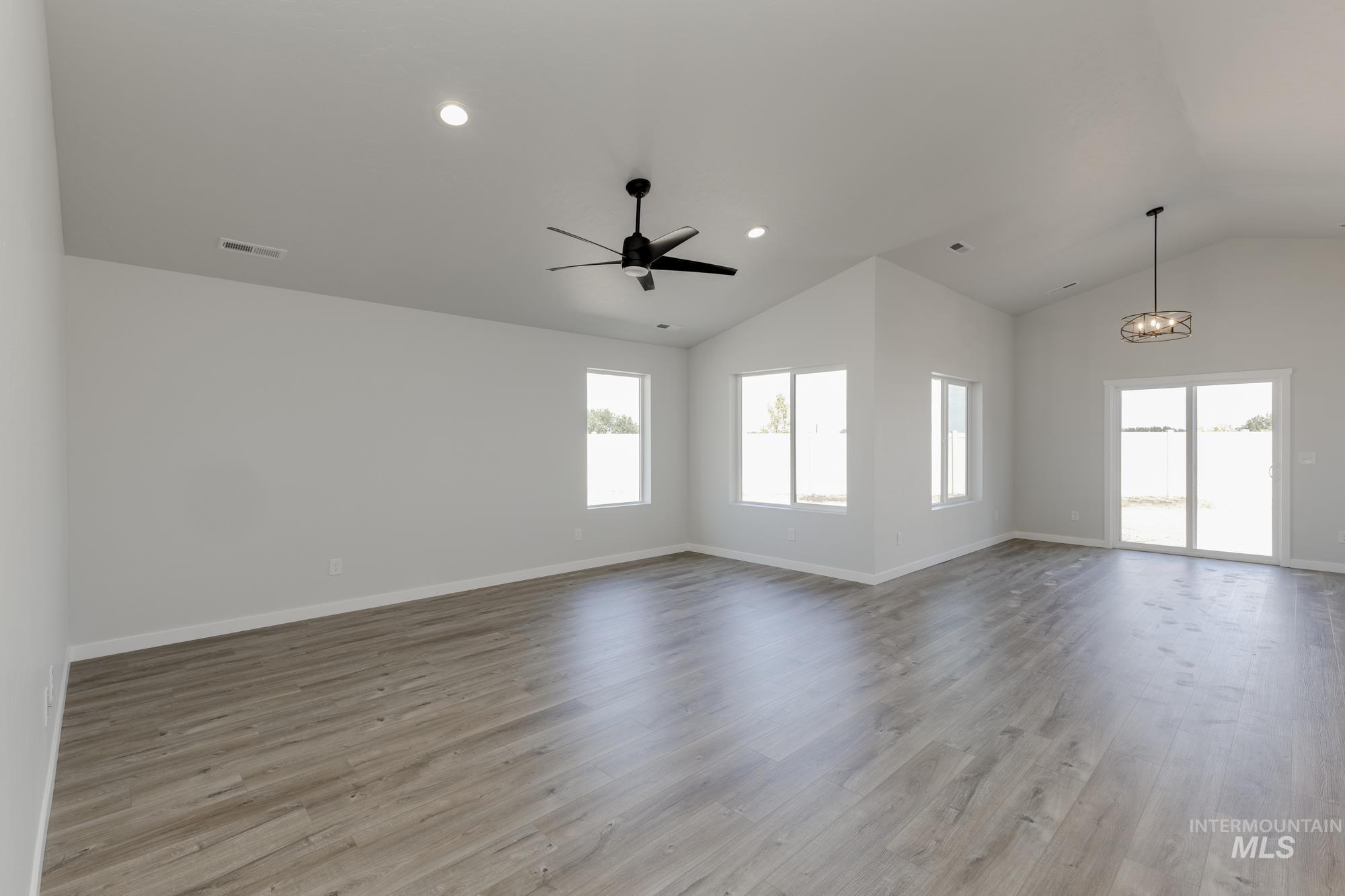 Empty room featuring light wood-style flooring, recessed lighting, ceiling fan, and high vaulted ceiling