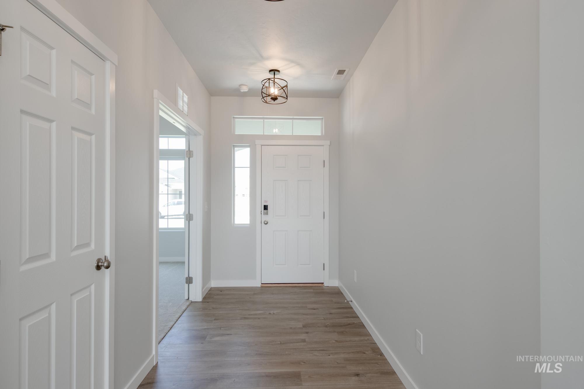 Entrance foyer featuring a chandelier and wood finished floors