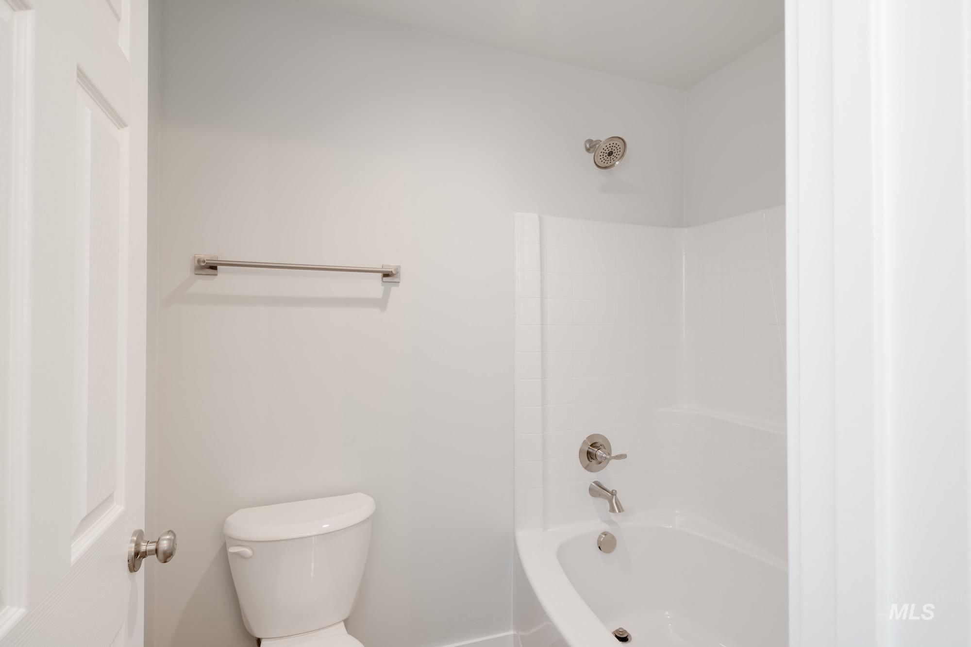 Bathroom featuring toilet and bathing tub / shower combination