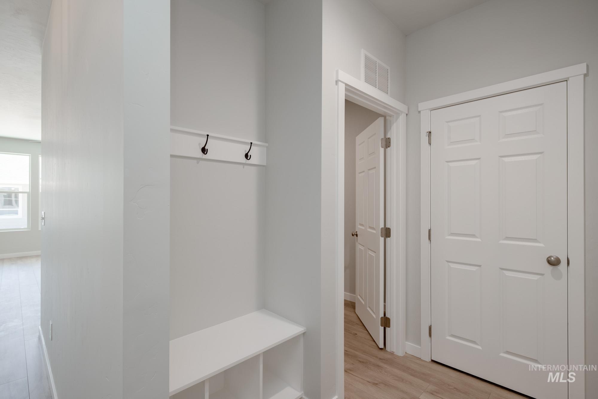 Mudroom featuring light wood finished floors and baseboards