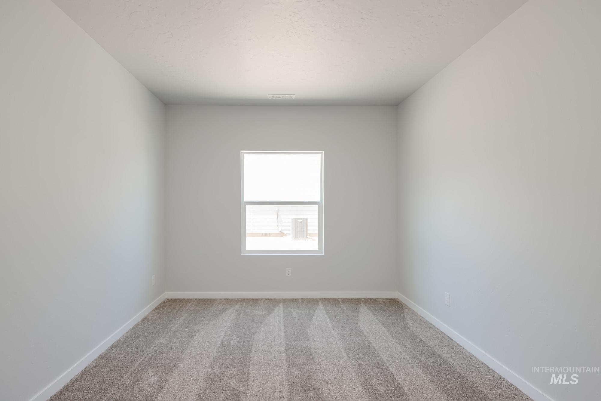 Unfurnished room with light colored carpet and baseboards