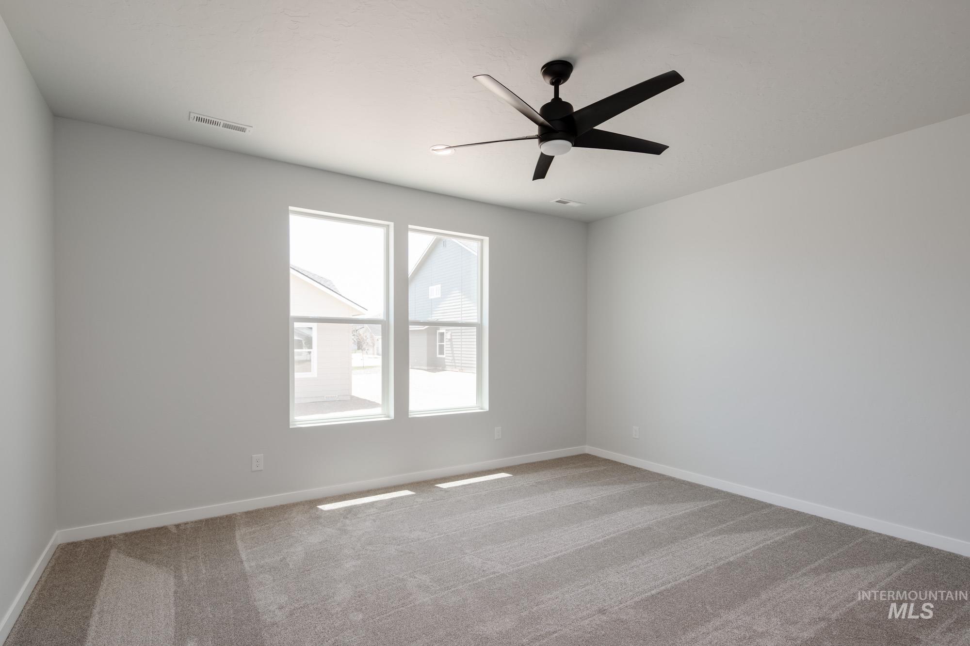Carpeted empty room with baseboards and ceiling fan