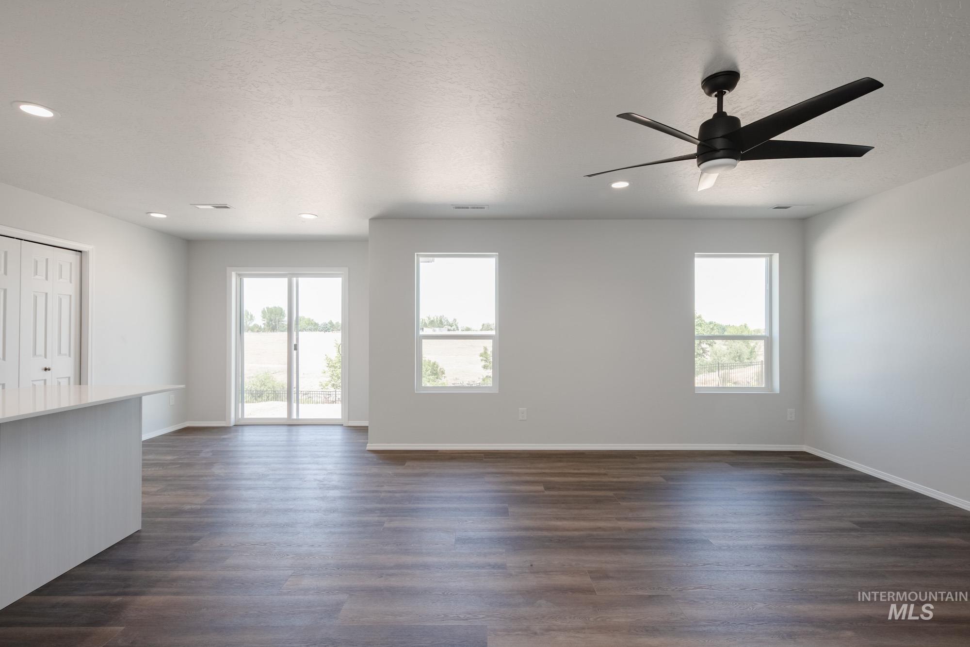 Unfurnished living room featuring recessed lighting, a ceiling fan, and dark wood-style flooring