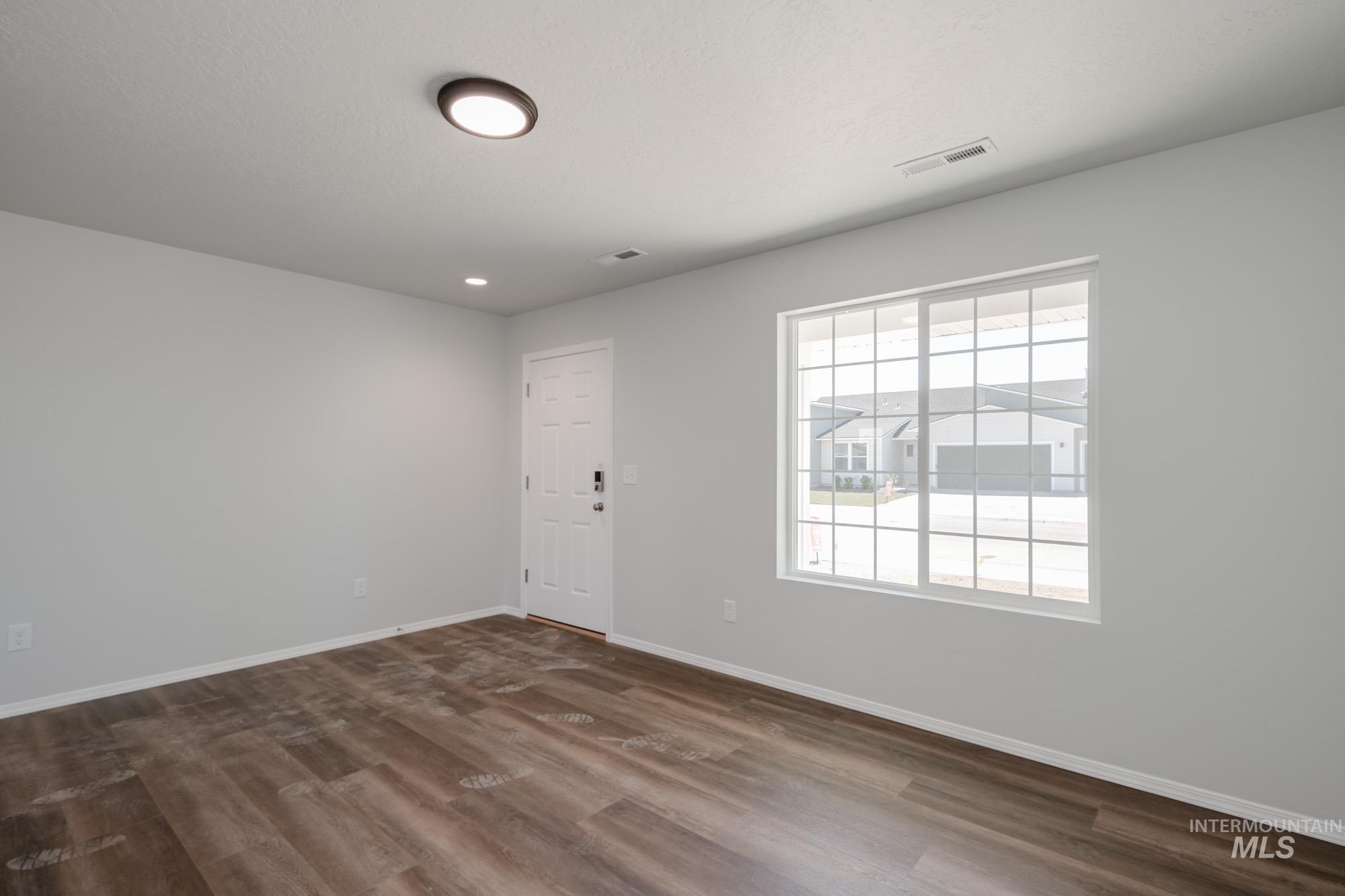 Unfurnished room featuring dark wood-style flooring and recessed lighting