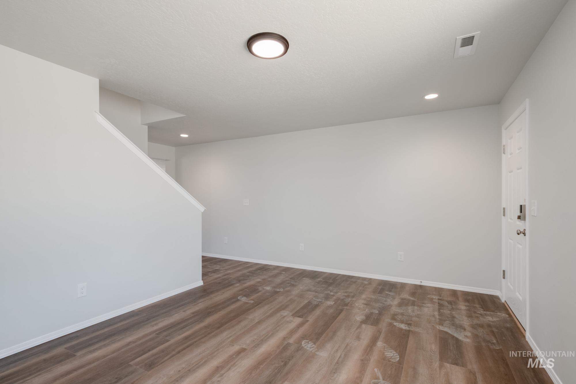 Below grade area with wood finished floors, recessed lighting, and stairs