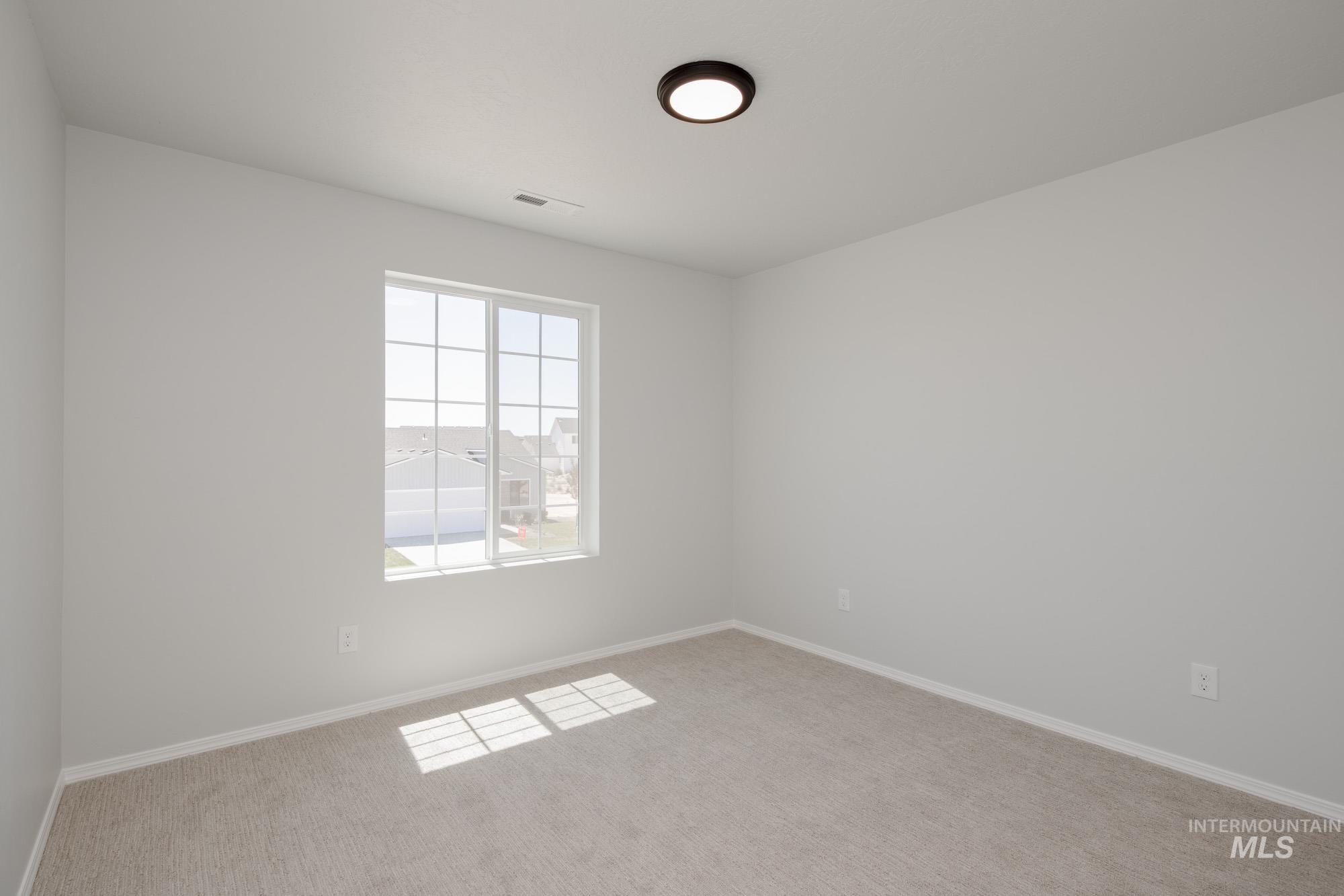 Carpeted spare room with baseboards