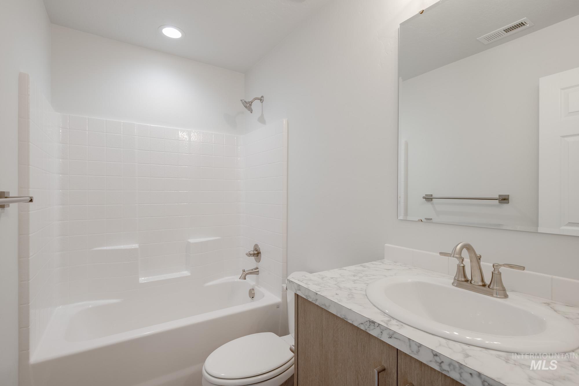 Full bath with vanity, shower / bath combination, and recessed lighting
