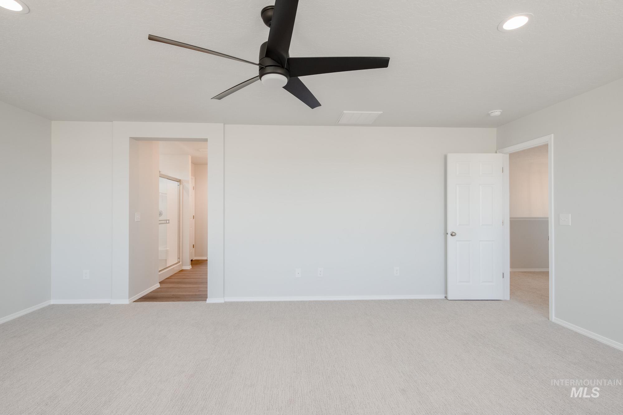 Spare room featuring light colored carpet, ceiling fan, and recessed lighting