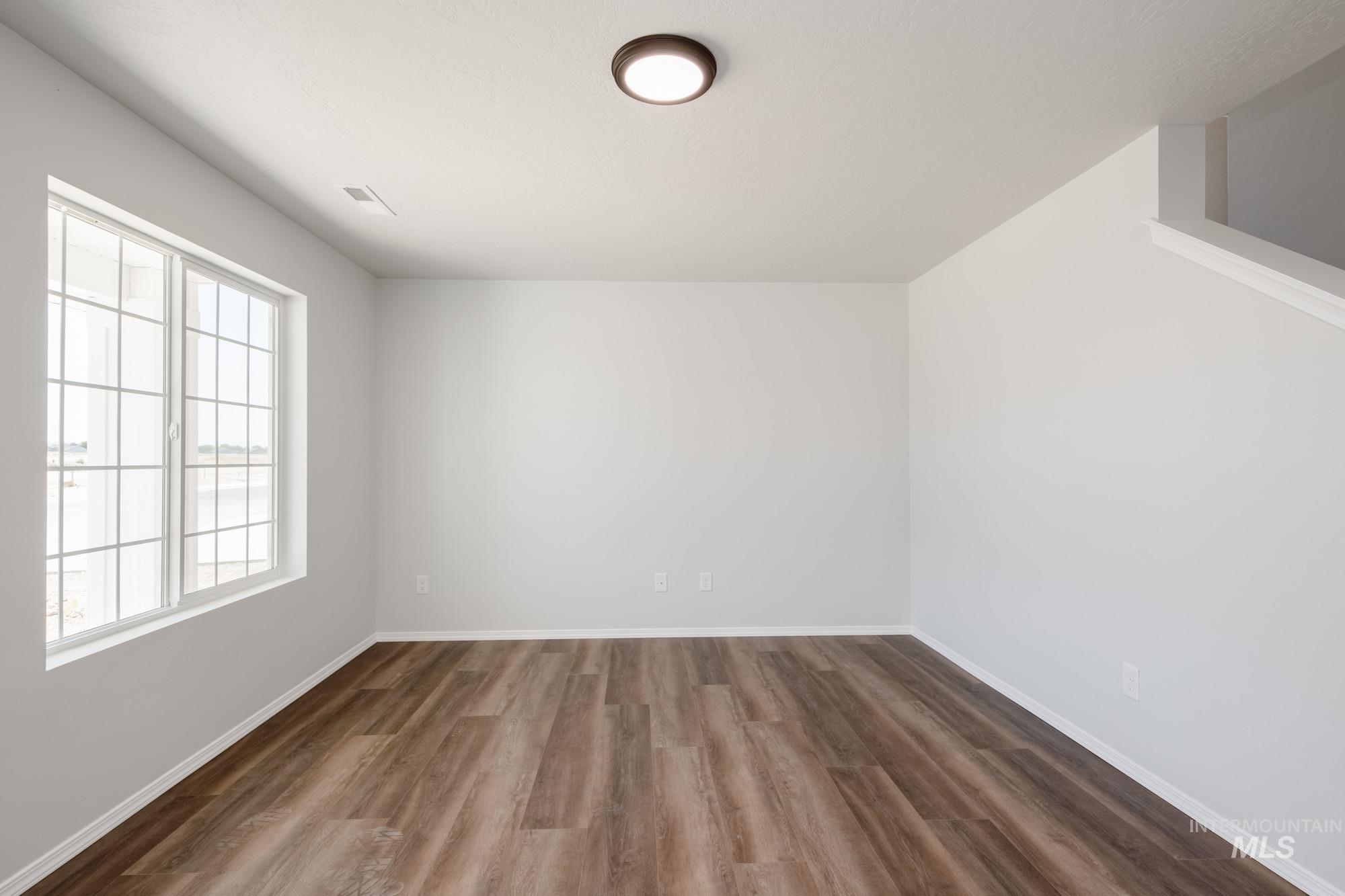 Spare room with wood finished floors and baseboards