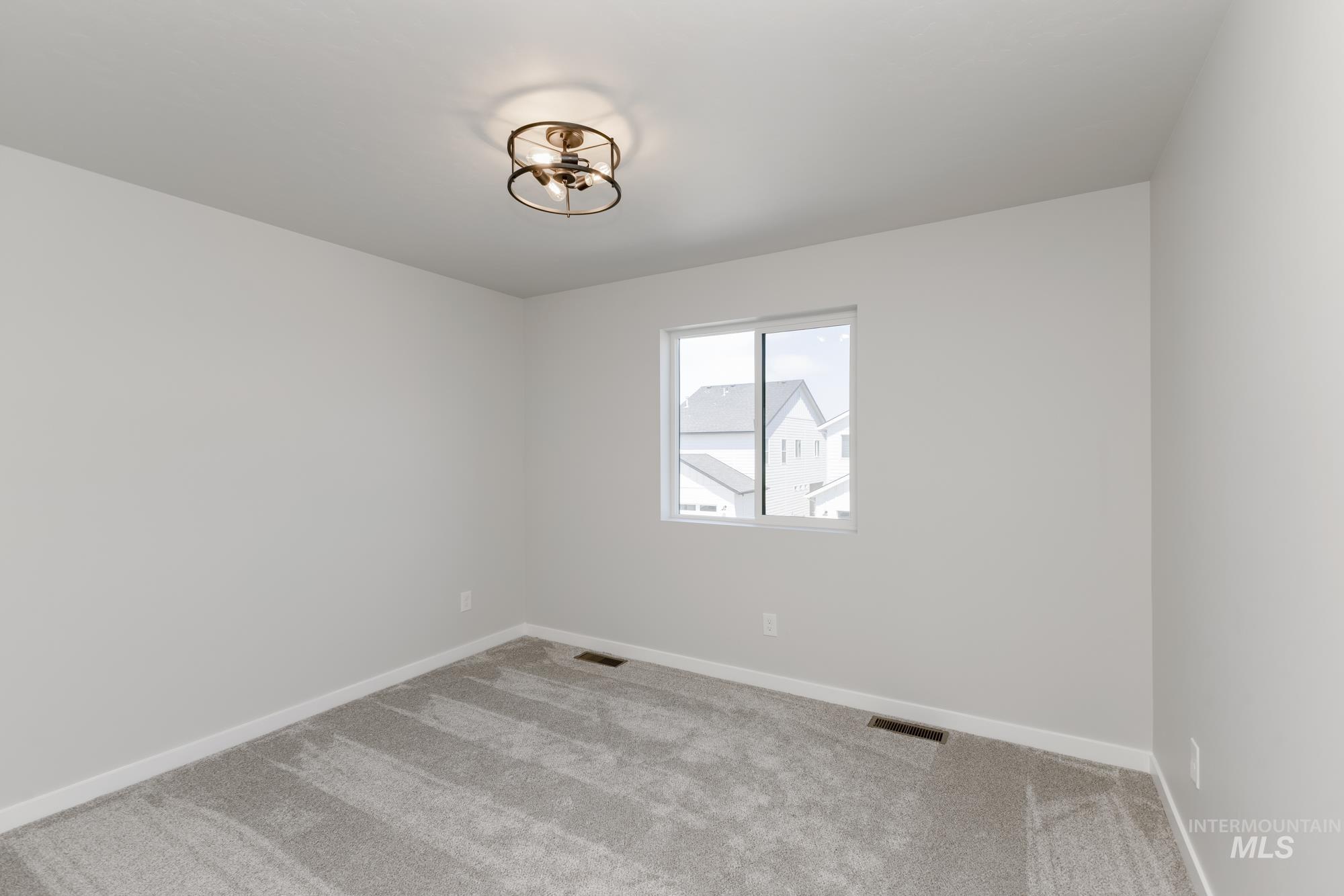 Spare room featuring carpet and baseboards