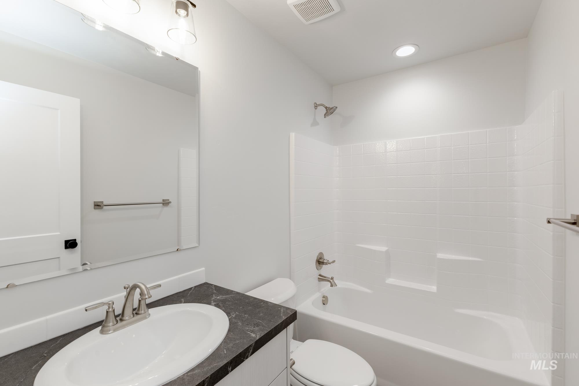 Full bathroom featuring vanity, shower / bathtub combination, and recessed lighting