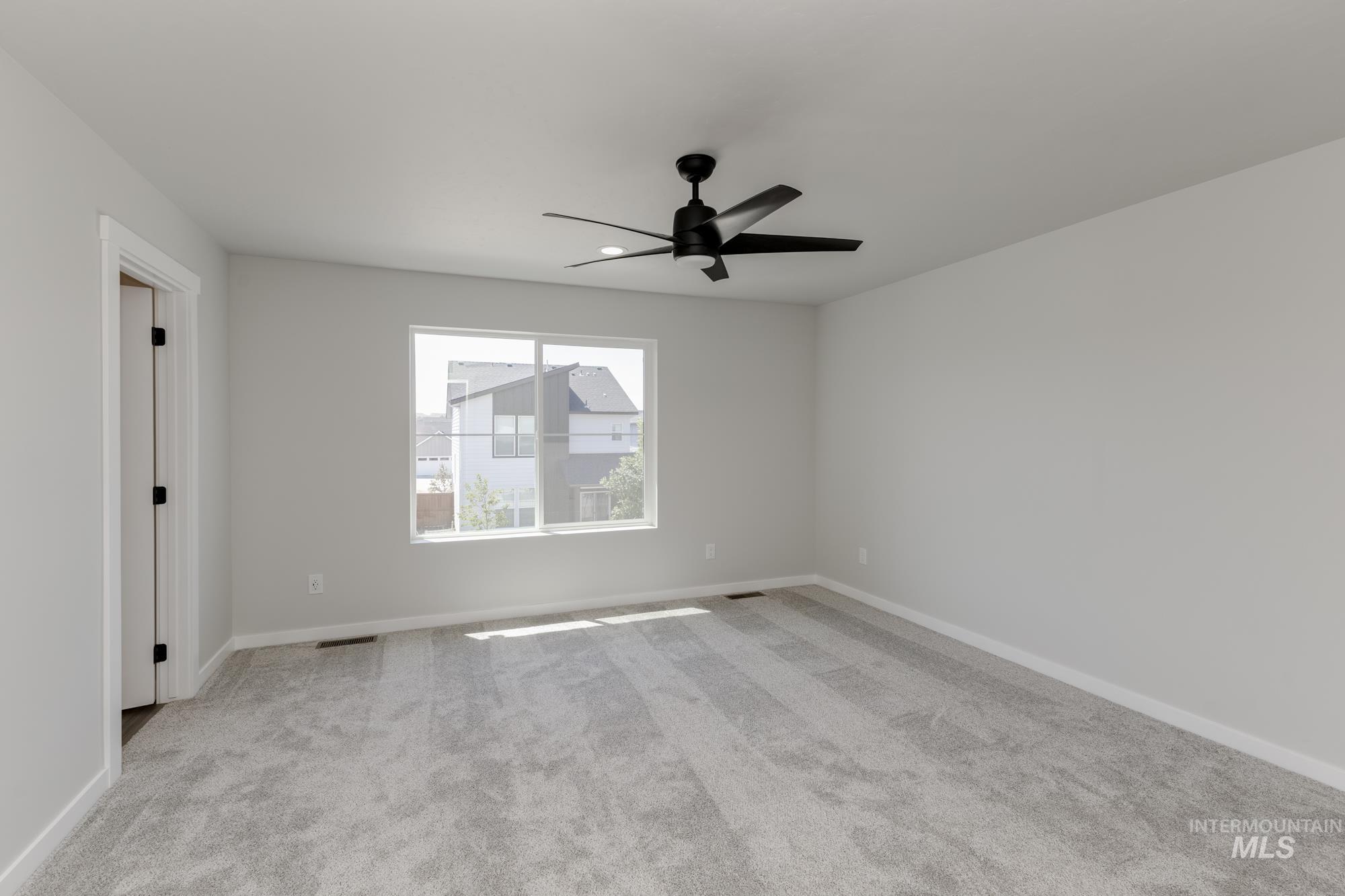 Spare room featuring carpet and a ceiling fan