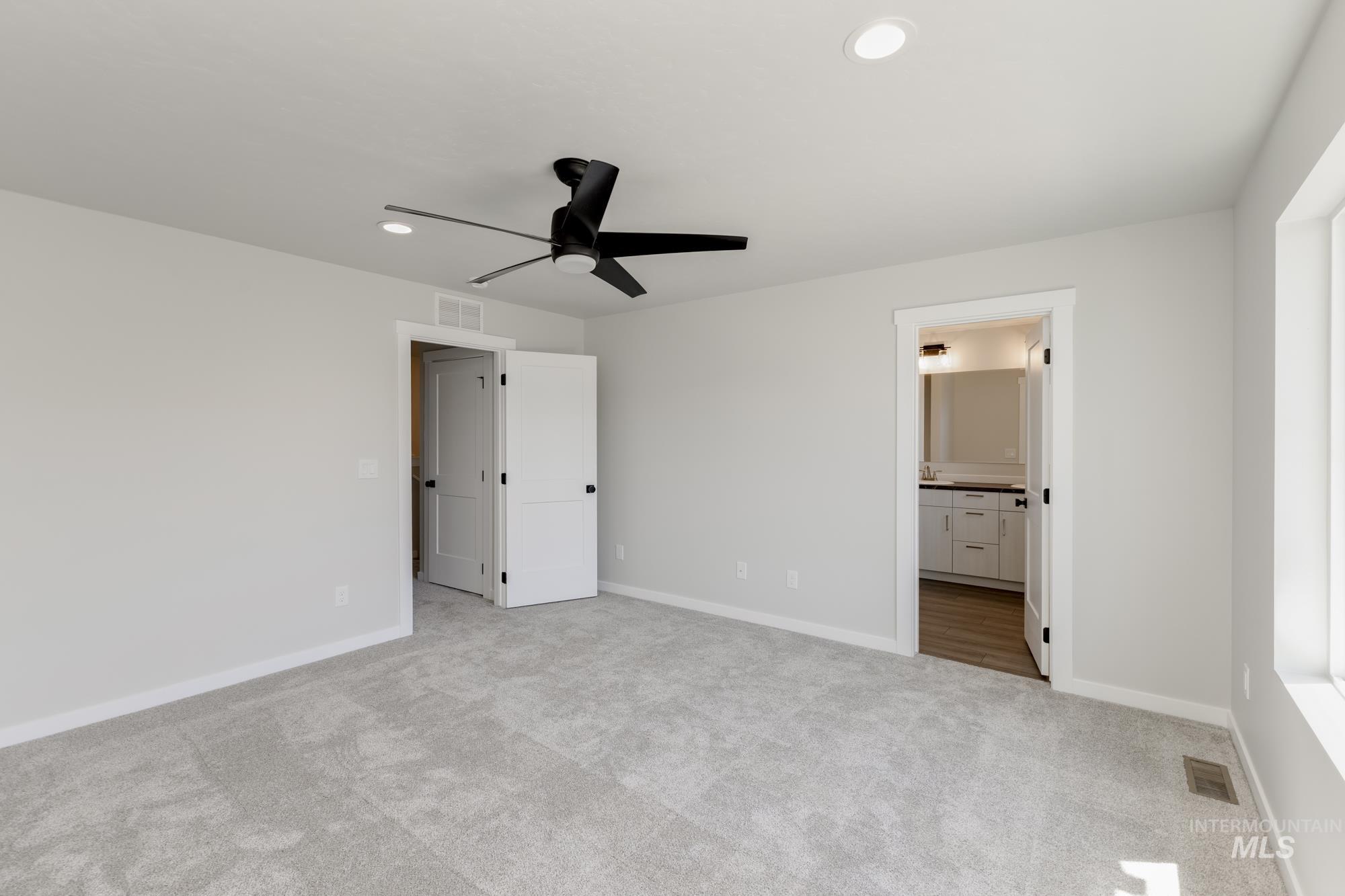 Unfurnished bedroom featuring carpet floors, recessed lighting, ensuite bathroom, and a ceiling fan