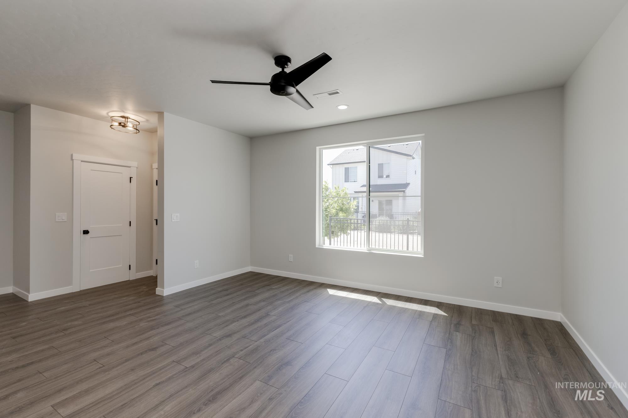 Spare room featuring dark wood-style floors, a ceiling fan, and recessed lighting