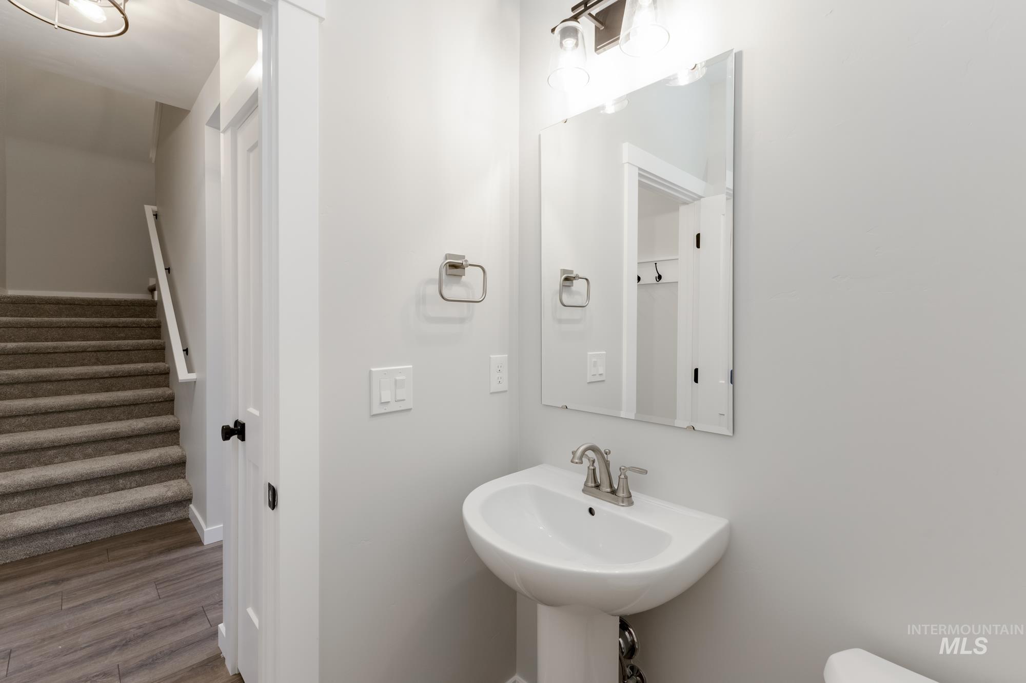 Half bathroom with wood finished floors and baseboards