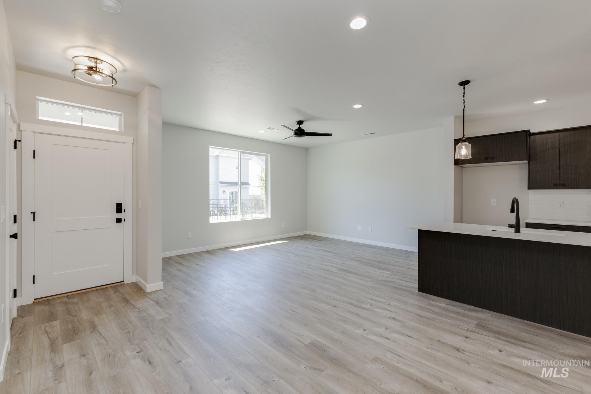 Entrance foyer with light wood-style floors, recessed lighting, and a ceiling fan