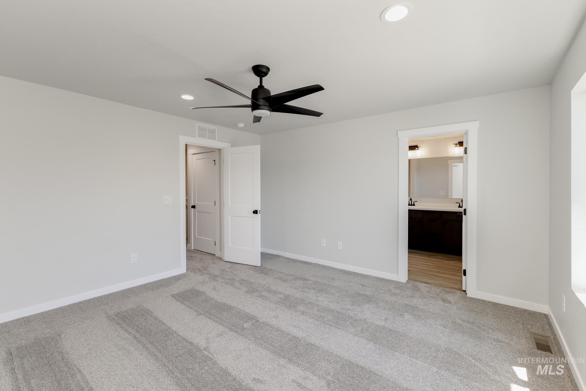Unfurnished bedroom with light carpet, recessed lighting, connected bathroom, and a ceiling fan