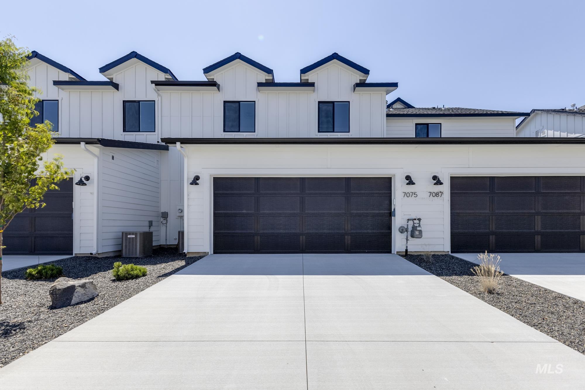 Modern inspired farmhouse with concrete driveway and board and batten siding
