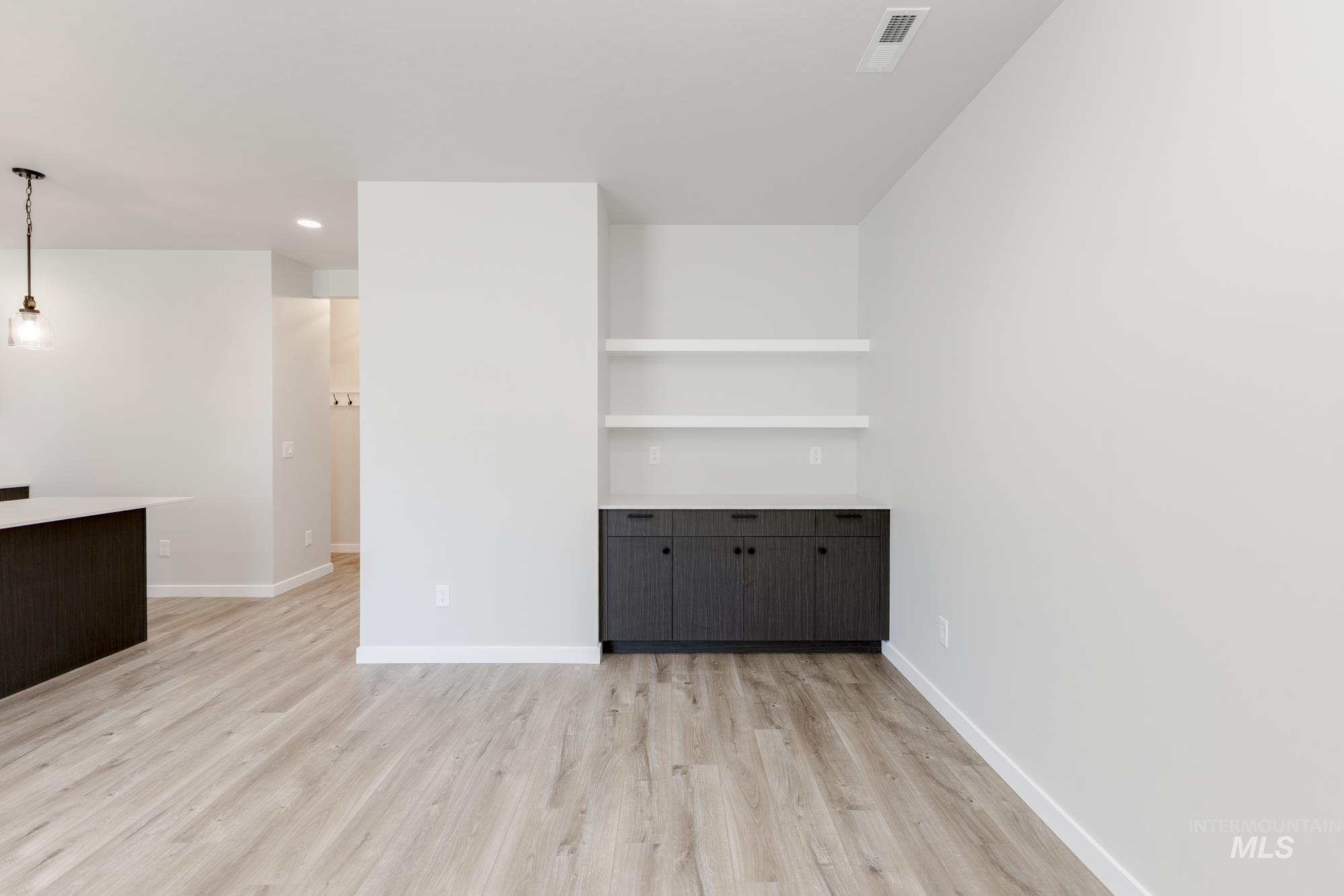 Unfurnished living room featuring light wood-type flooring, recessed lighting, and built in shelves