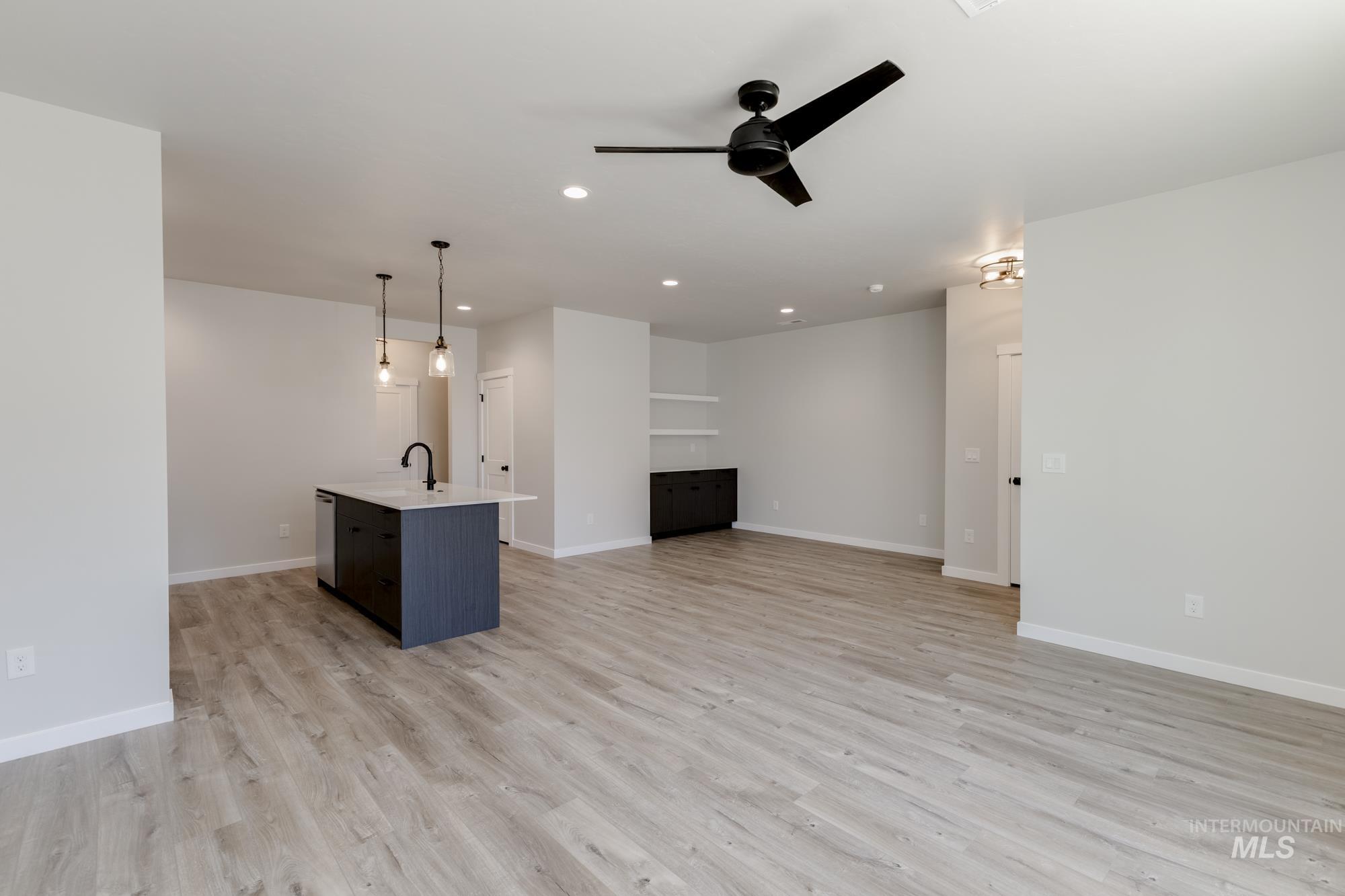 Unfurnished living room featuring light wood-type flooring, ceiling fan, and recessed lighting