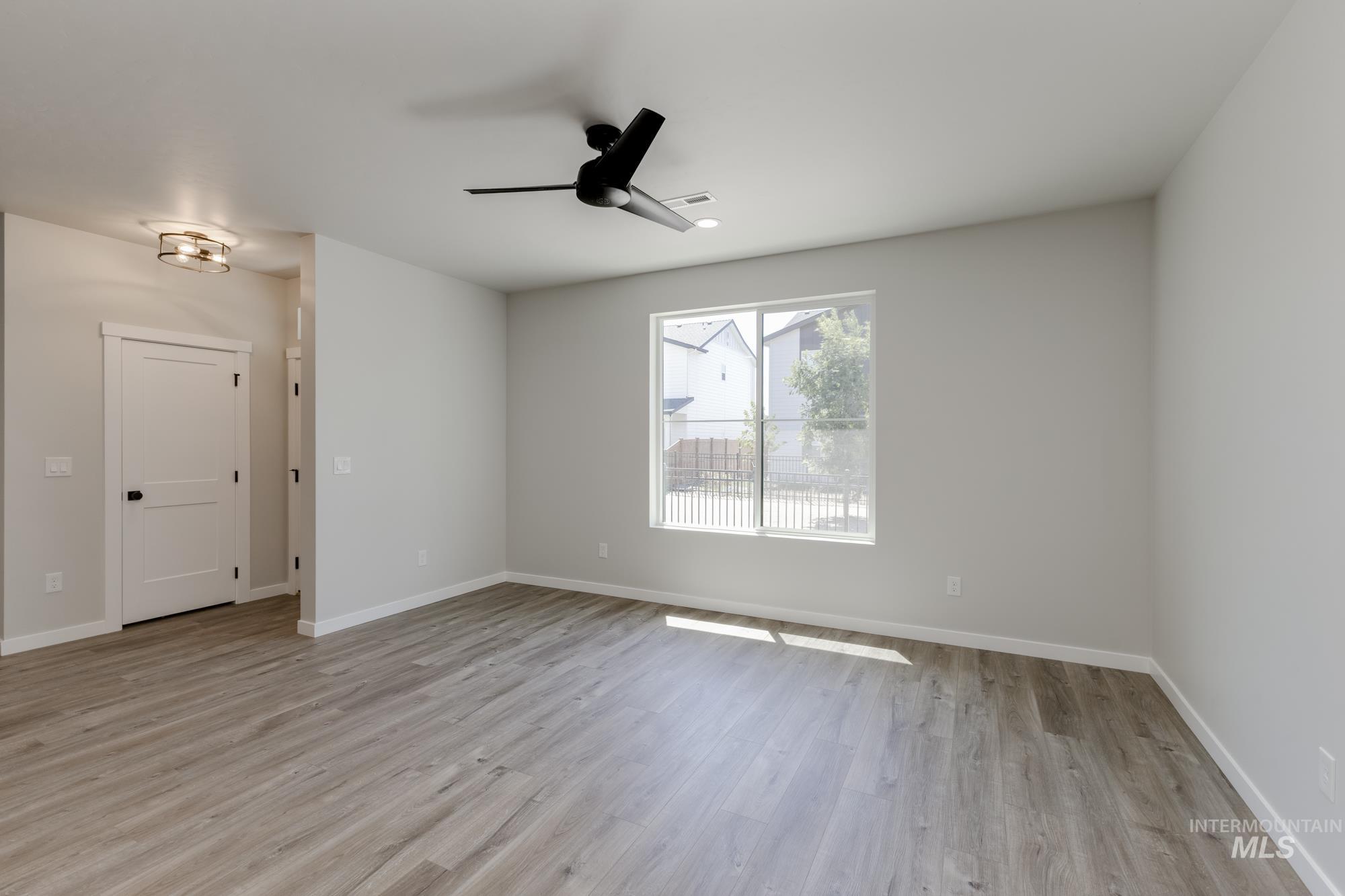 Spare room with light wood finished floors and a ceiling fan