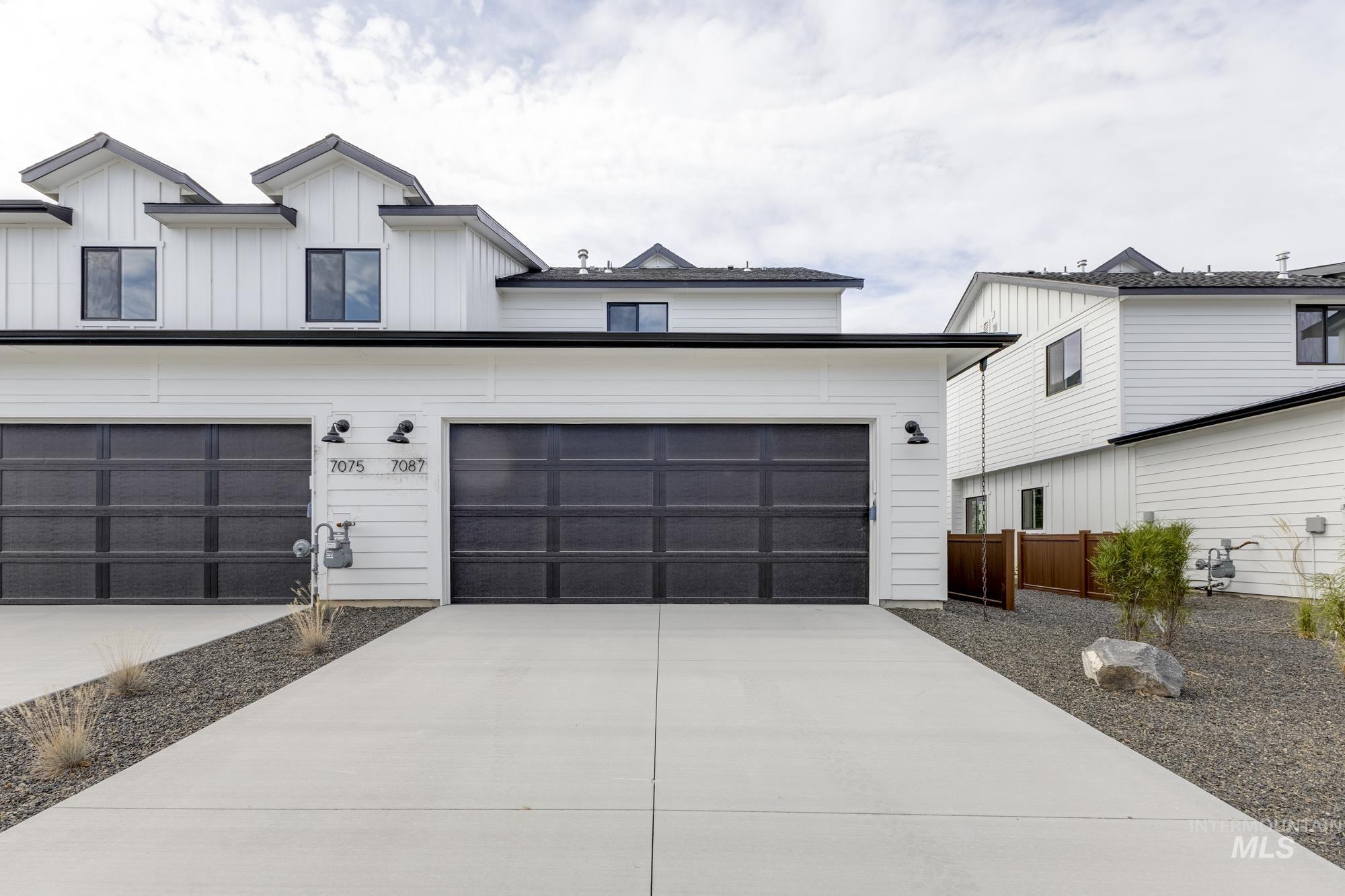 Modern farmhouse with concrete driveway, board and batten siding, and a garage