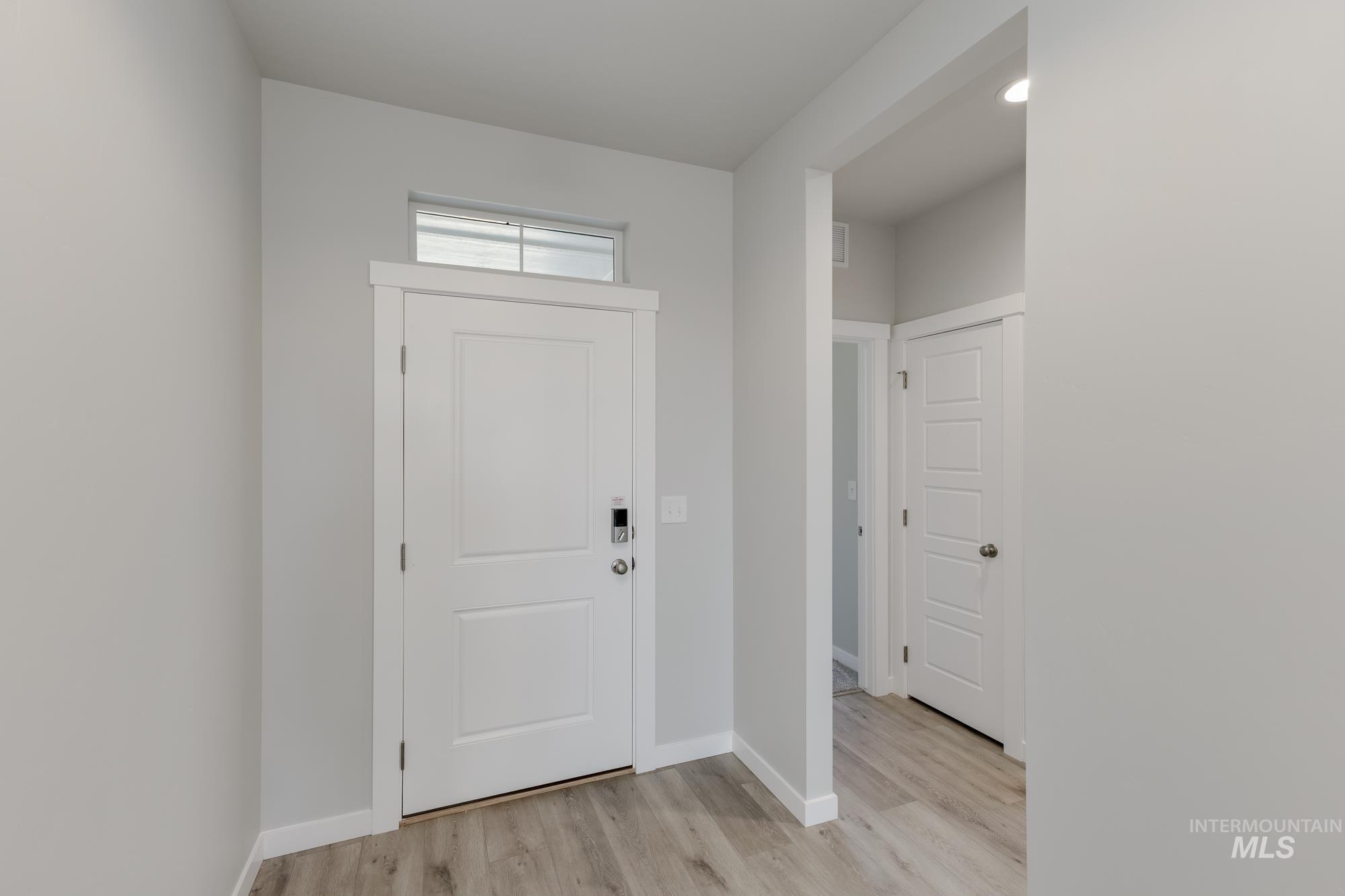 Entrance foyer featuring light wood-style floors