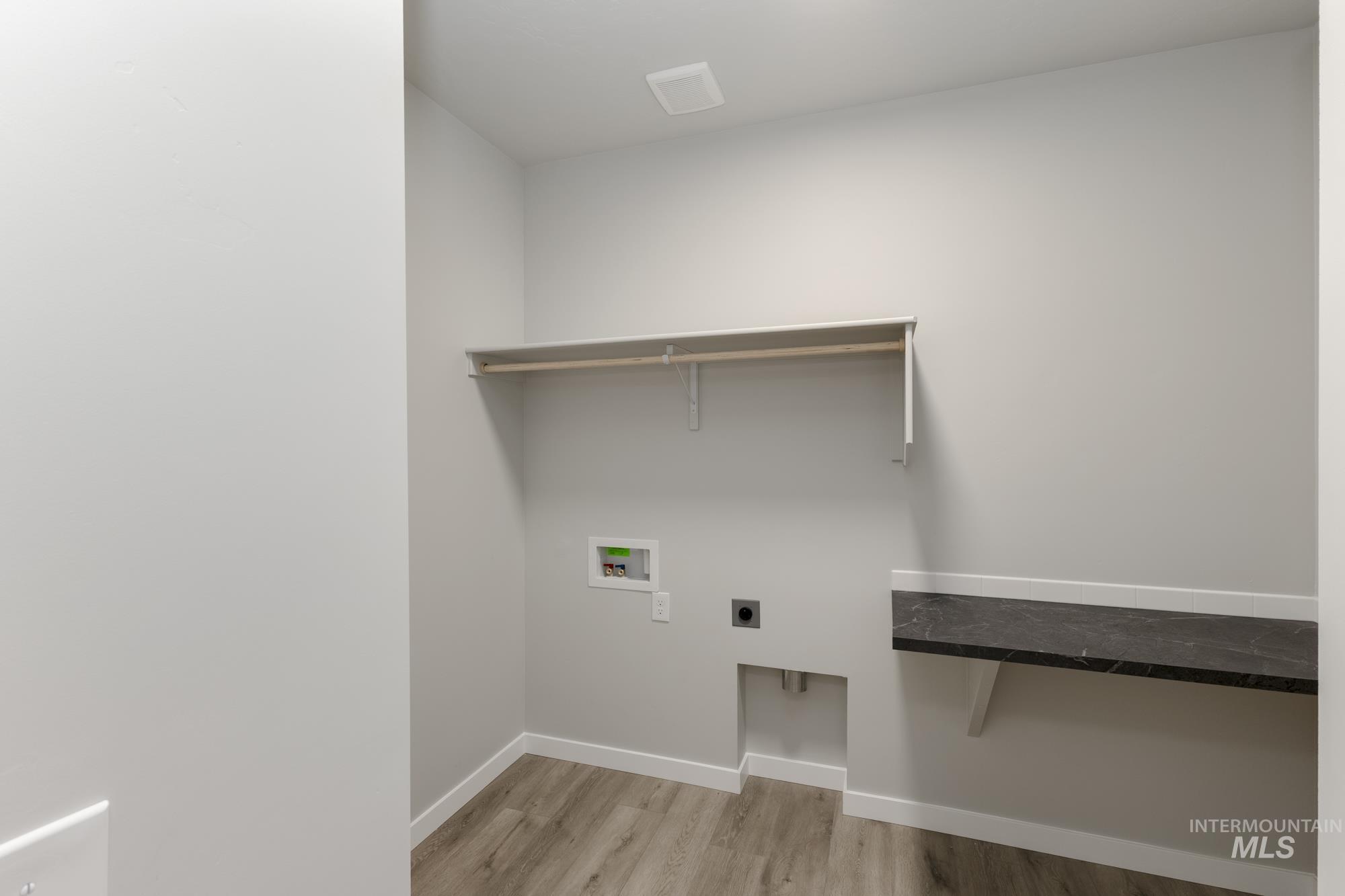 Laundry area featuring hookup for an electric dryer, light wood-style floors, and washer hookup