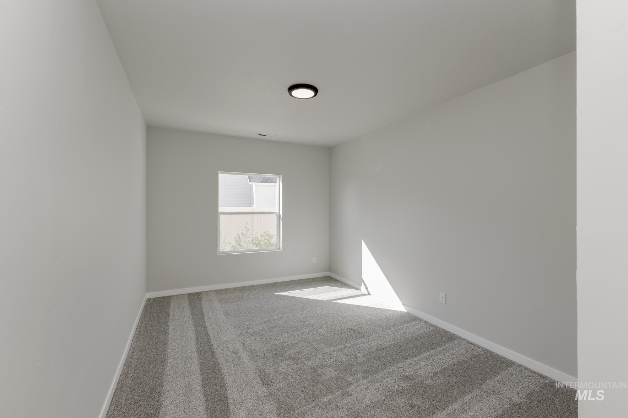 Empty room featuring baseboards and carpet flooring