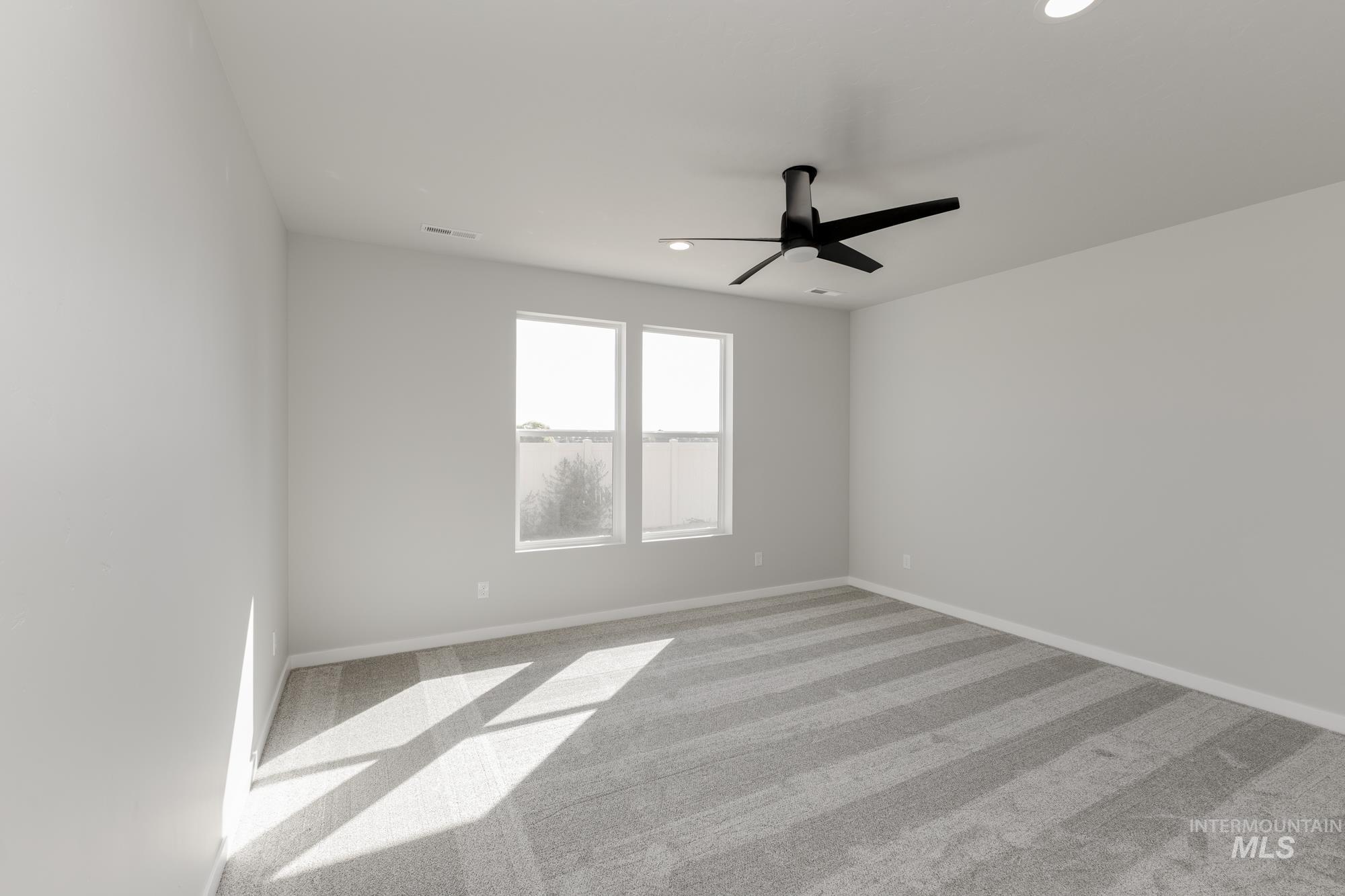 Carpeted empty room with ceiling fan and recessed lighting