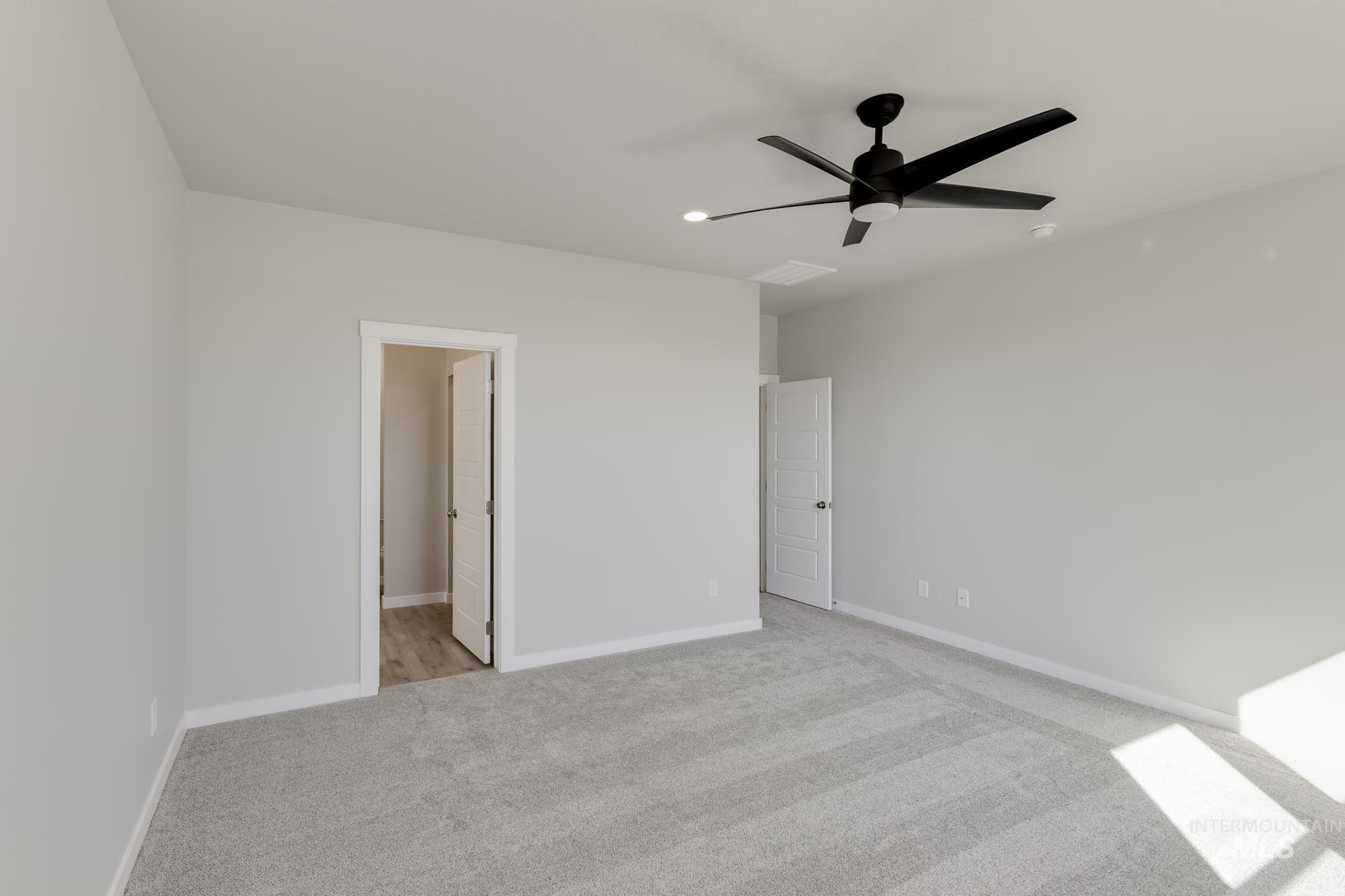 Unfurnished bedroom featuring light carpet and ceiling fan