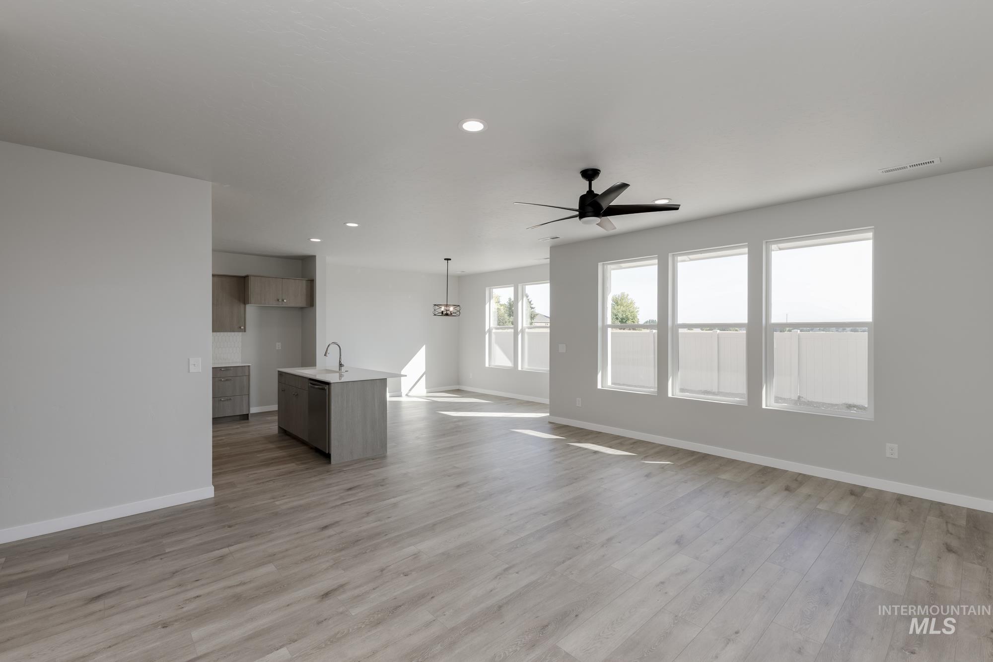 Unfurnished living room featuring a ceiling fan, recessed lighting, and light wood finished floors