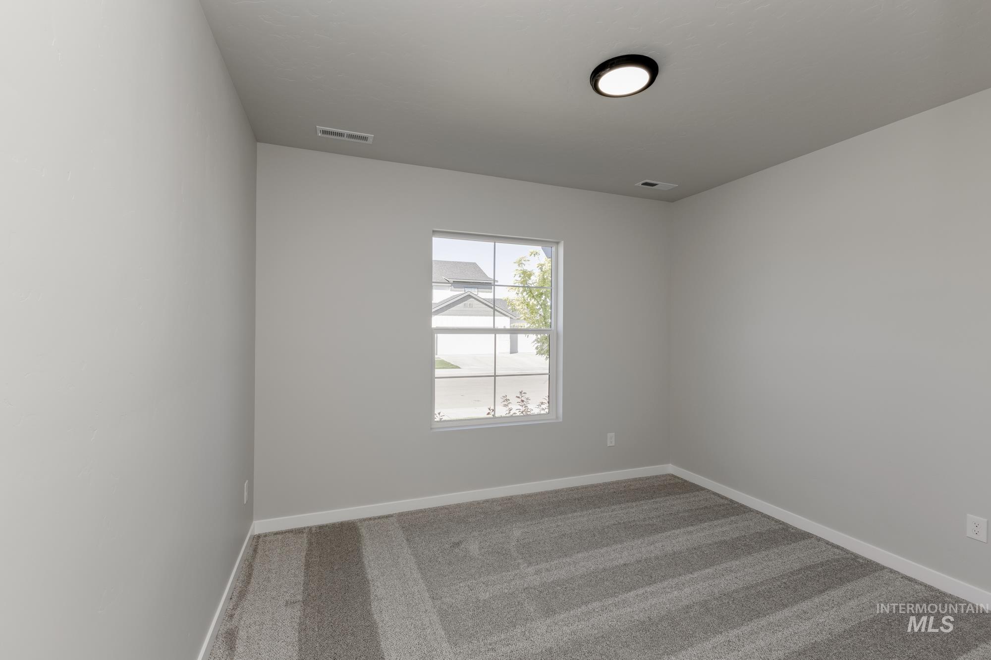 Empty room featuring carpet flooring and baseboards