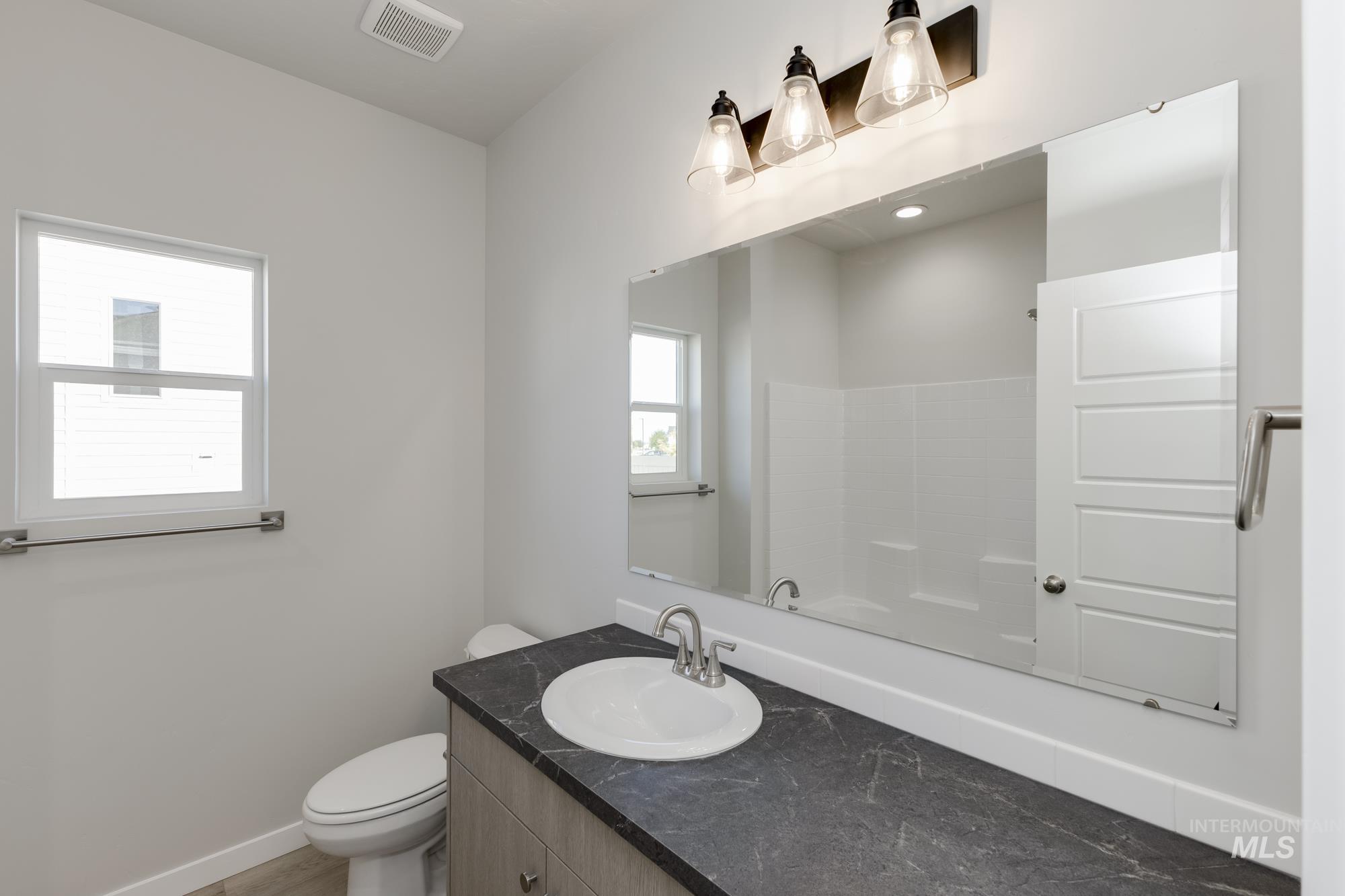 Full bath featuring vanity and toilet