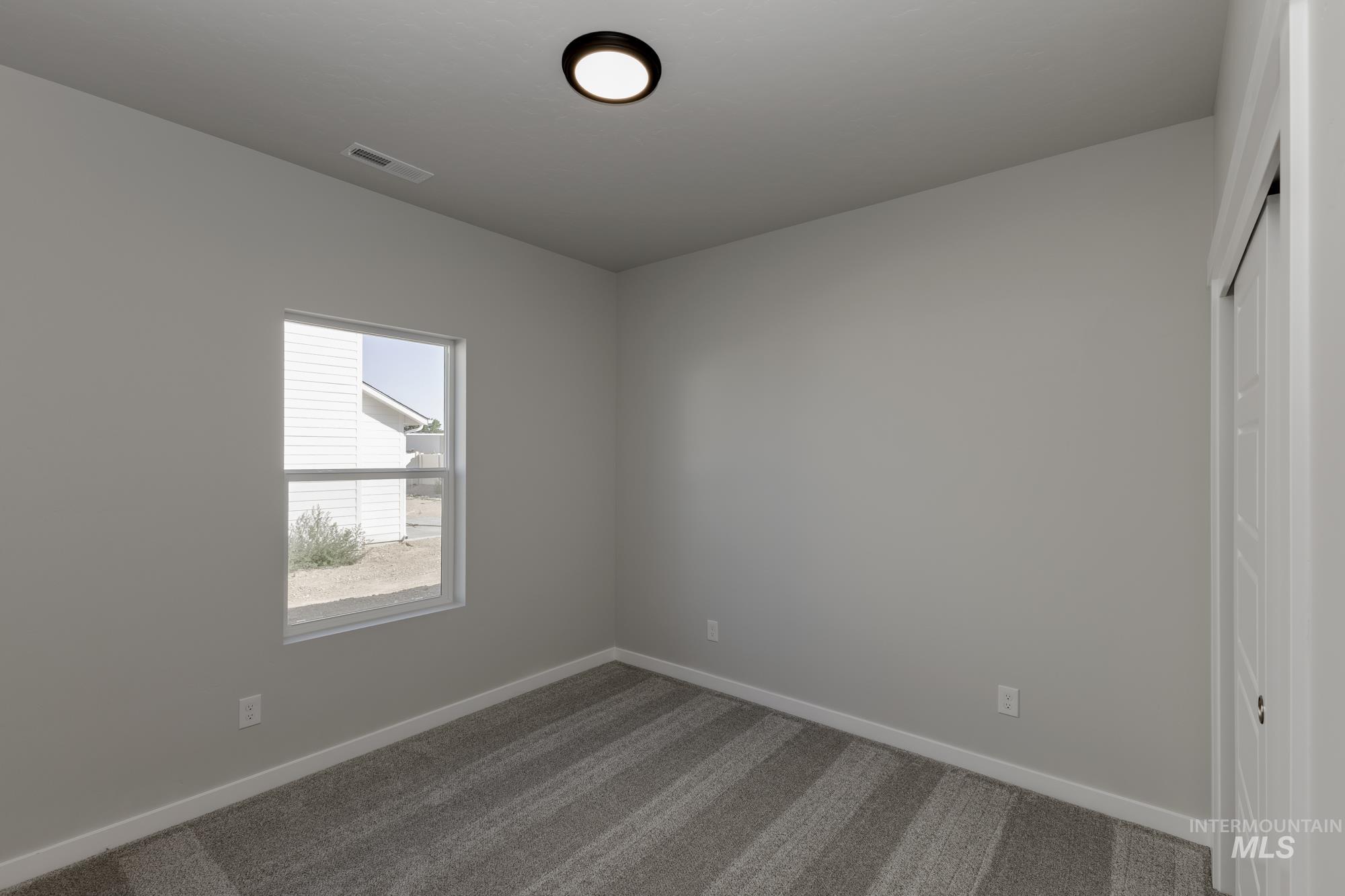 Spare room featuring dark colored carpet