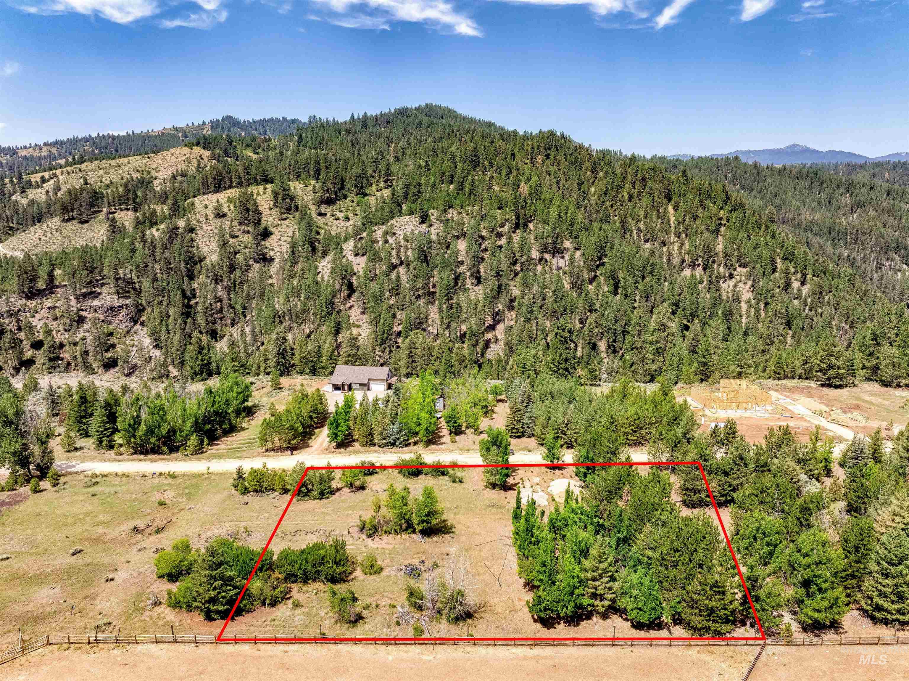 Aerial view of property and surrounding area featuring a heavily wooded area and property parcel outlined