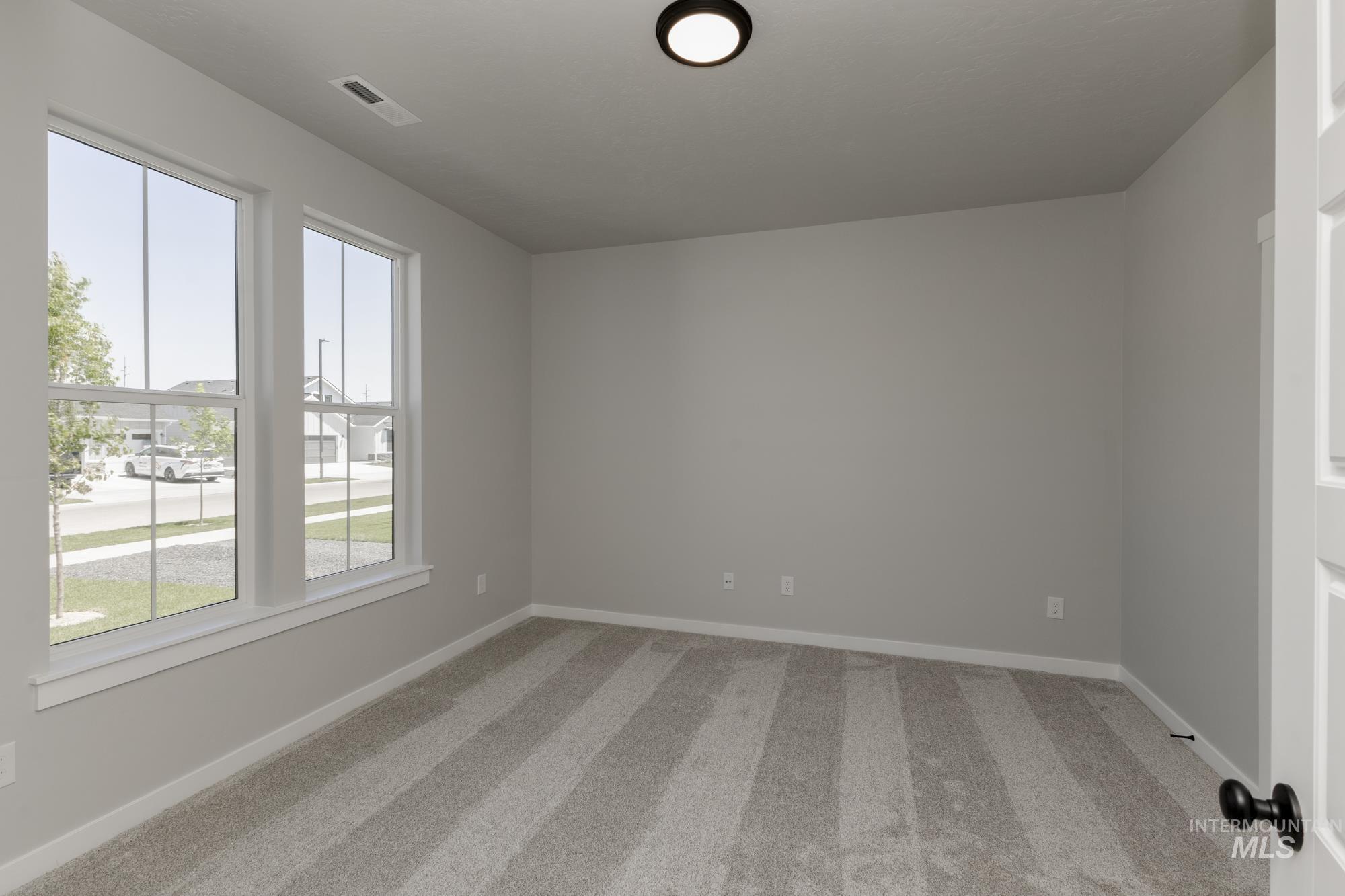 Carpeted empty room featuring baseboards