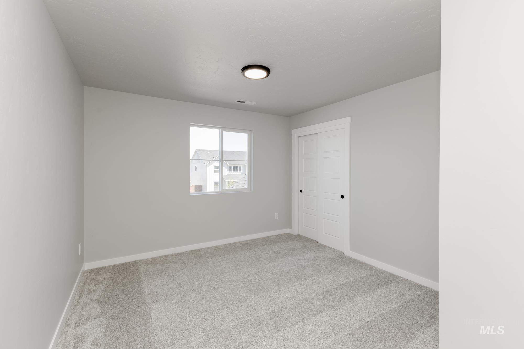 Empty room with carpet and baseboards