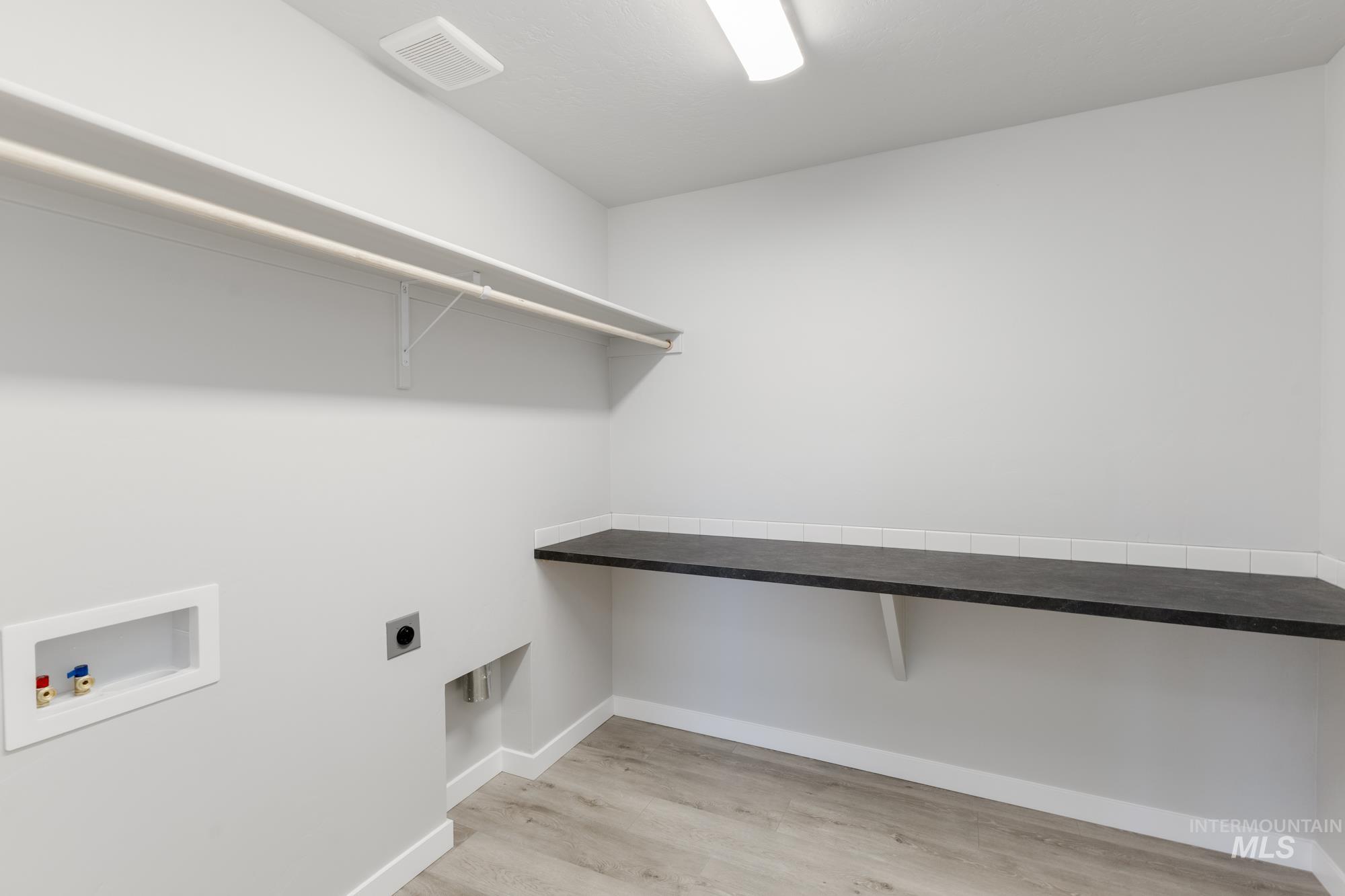 Laundry area with washer hookup, hookup for an electric dryer, and light wood finished floors