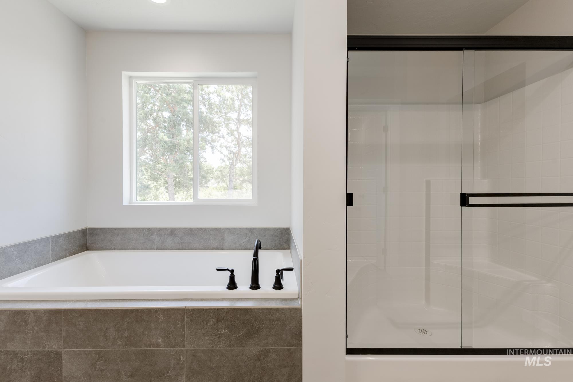 Bathroom featuring a garden tub and a shower stall