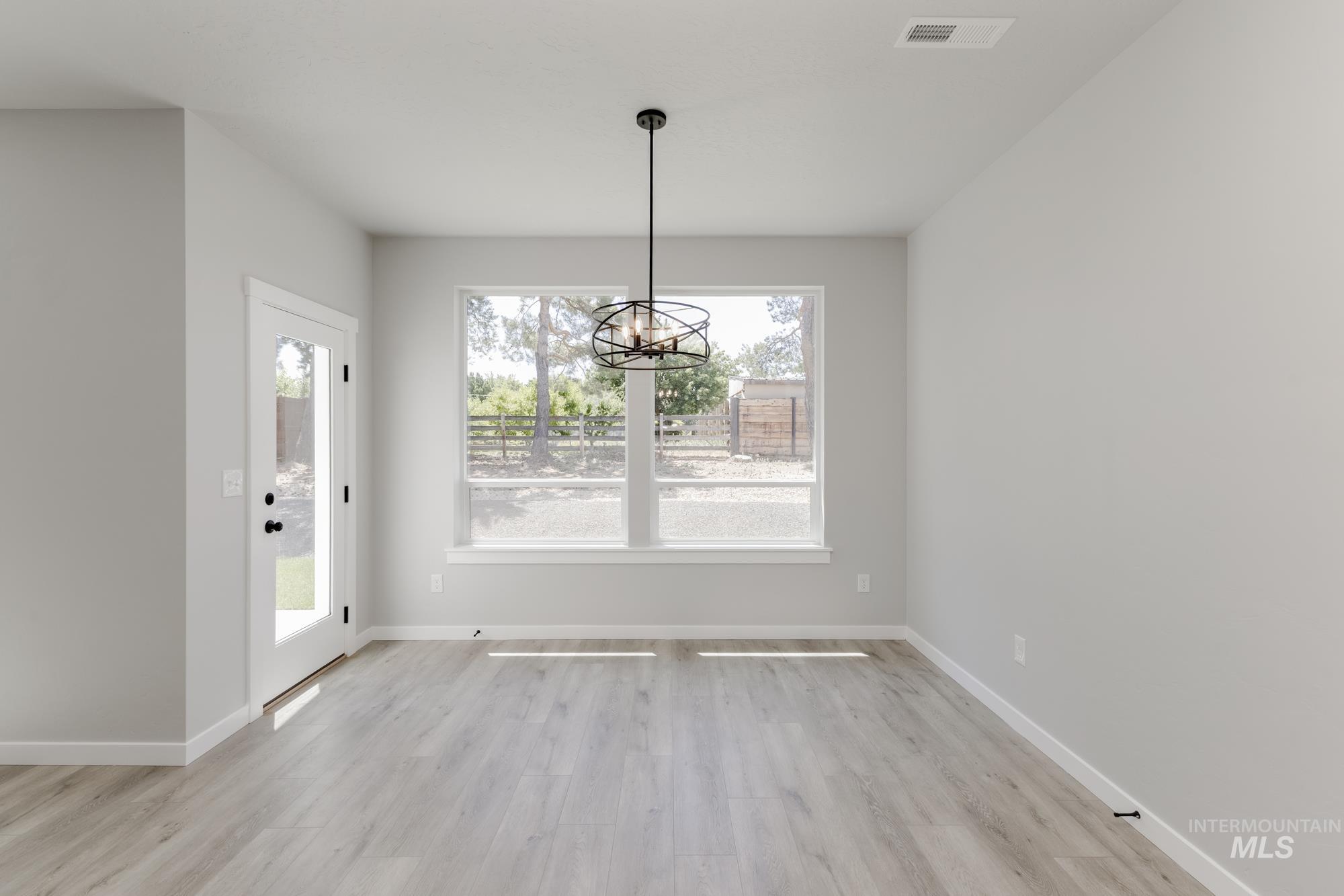 Unfurnished dining area featuring a chandelier and light wood finished floors