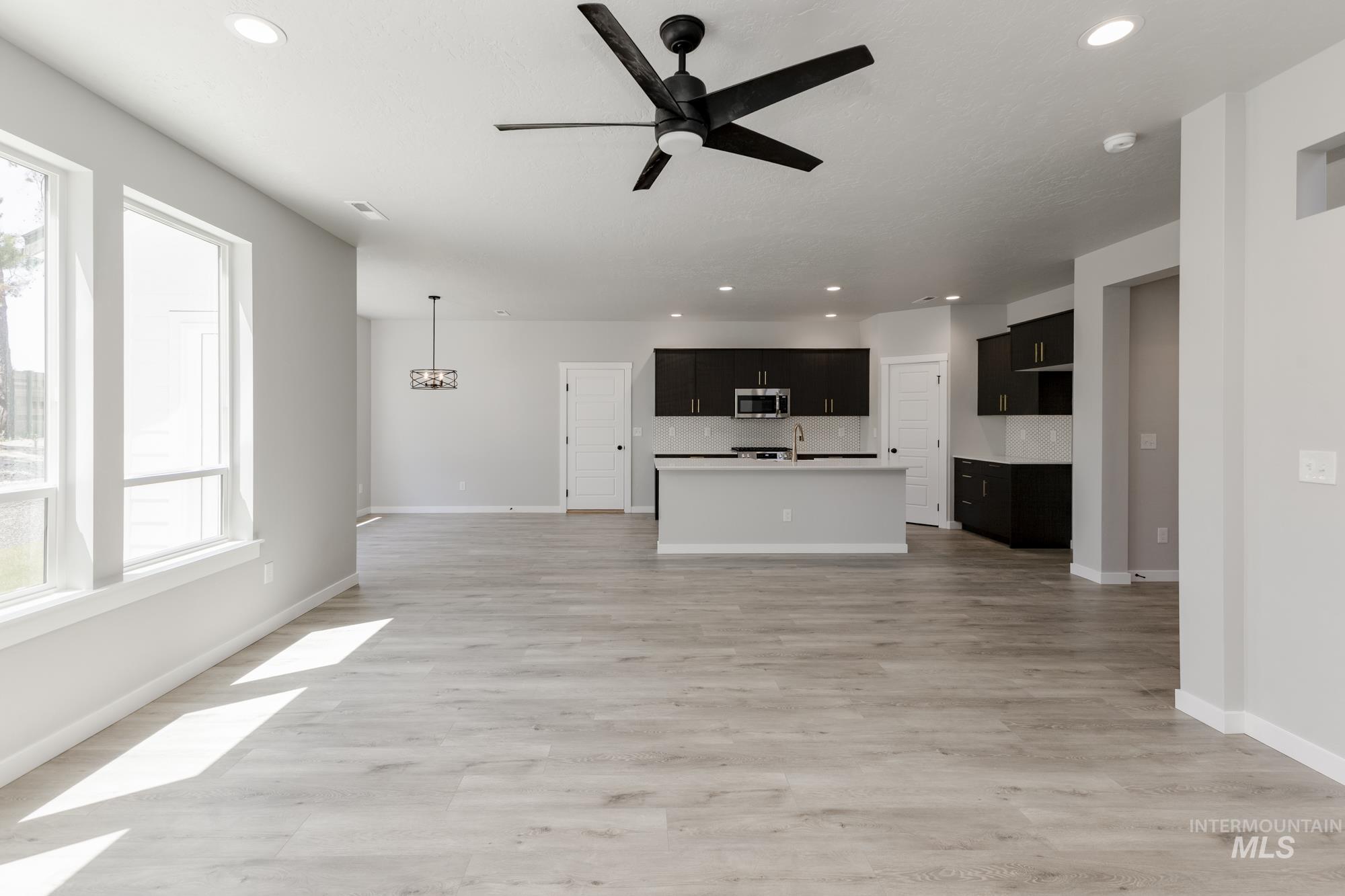 Unfurnished living room with ceiling fan, recessed lighting, and light wood-style flooring